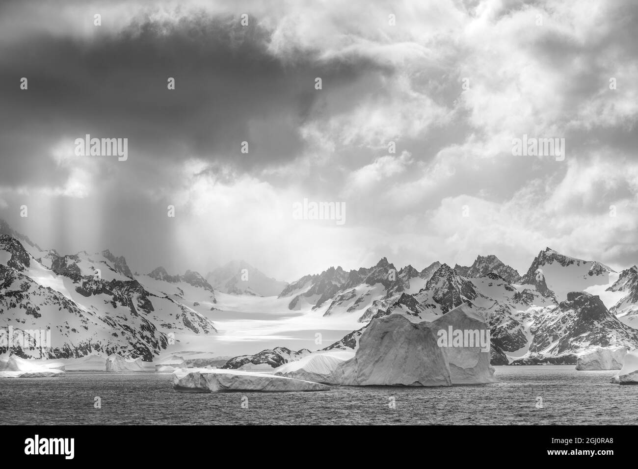 Antarctique, Île de Géorgie du Sud. Des rayons de soleil illuminent les icebergs et les montagnes. Credit AS: Don Gral / Galerie Jaynes / DanitaDelimont.com Banque D'Images