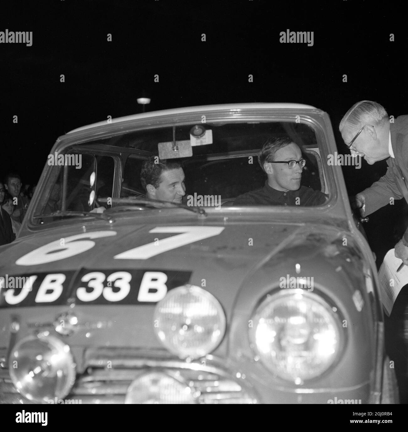 Athènes , Grèce : Un dernier mot de bonne chance pour l'équipe britannique de rallye Monte Carlo de Paddy Hopkirk (à gauche) et Henry Liddon avant de partir dans leur Morris Cooper '' S '' sur le 12ème rallye Acropolis de 2886 km . Quelque 96 conducteurs sont venus d'ici et se termineront ici, au pied de l'Acropole, le 15 mai 1964 Banque D'Images
