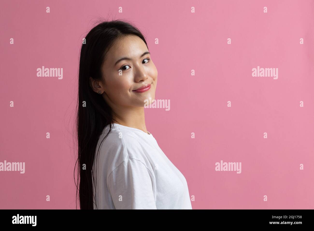 Portrait demi tour de femme asiatique sur fond rose. Banque D'Images