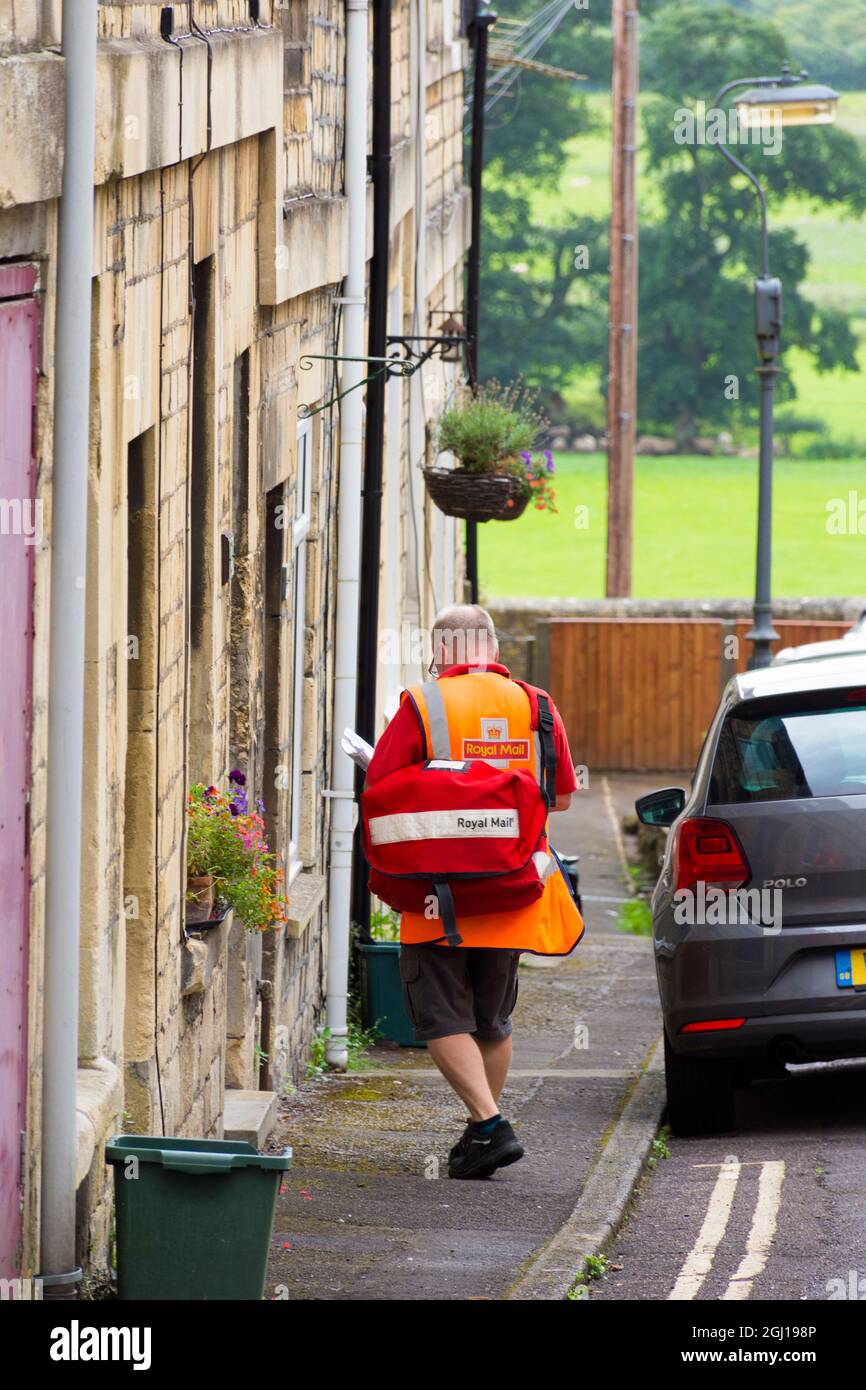 Royal Mail postman sur son tour de livraison, Batheaston, Bath, Angleterre, Royaume-Uni Banque D'Images