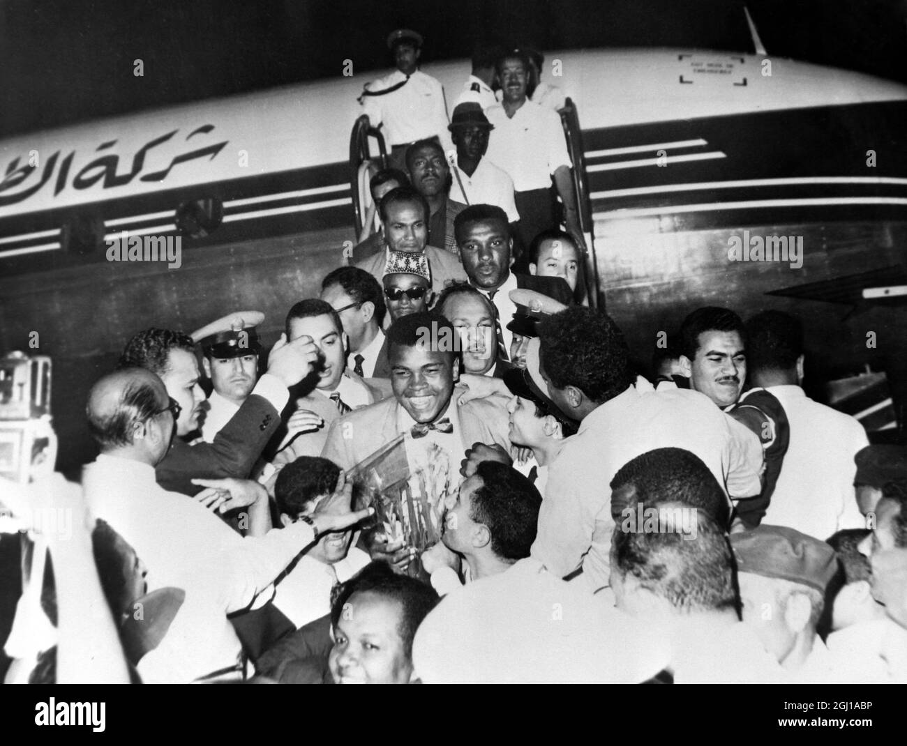 4 JUIN 1964 le champion mondial de poids lourd de boxe, Muhammad Ali, officiellement Cassius Clay entouré de foules après son arrivée à l'aéroport du Caire, en Égypte. Banque D'Images