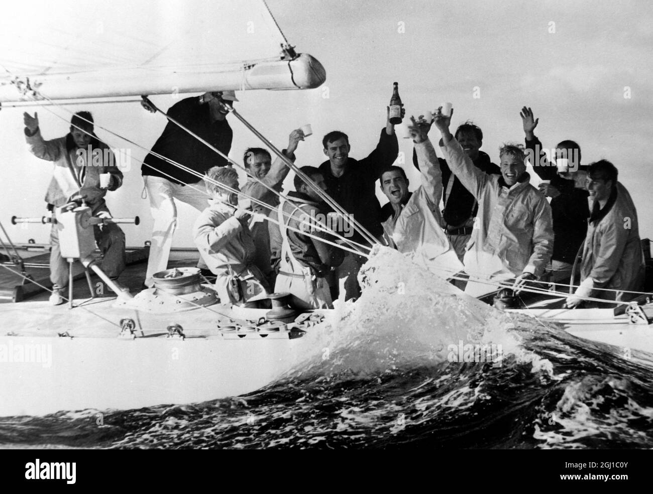 22 SEPTEMBRE 1964 les membres de l'équipage victorieux du défenseur américain Constellation boivent du champagne à bord de leur yacht après avoir battu le challenger britannique, Sovereign, dans la quatrième et dernière course pour la coupe de l'Amérique. Newport, Rhode Island, États-Unis. Banque D'Images