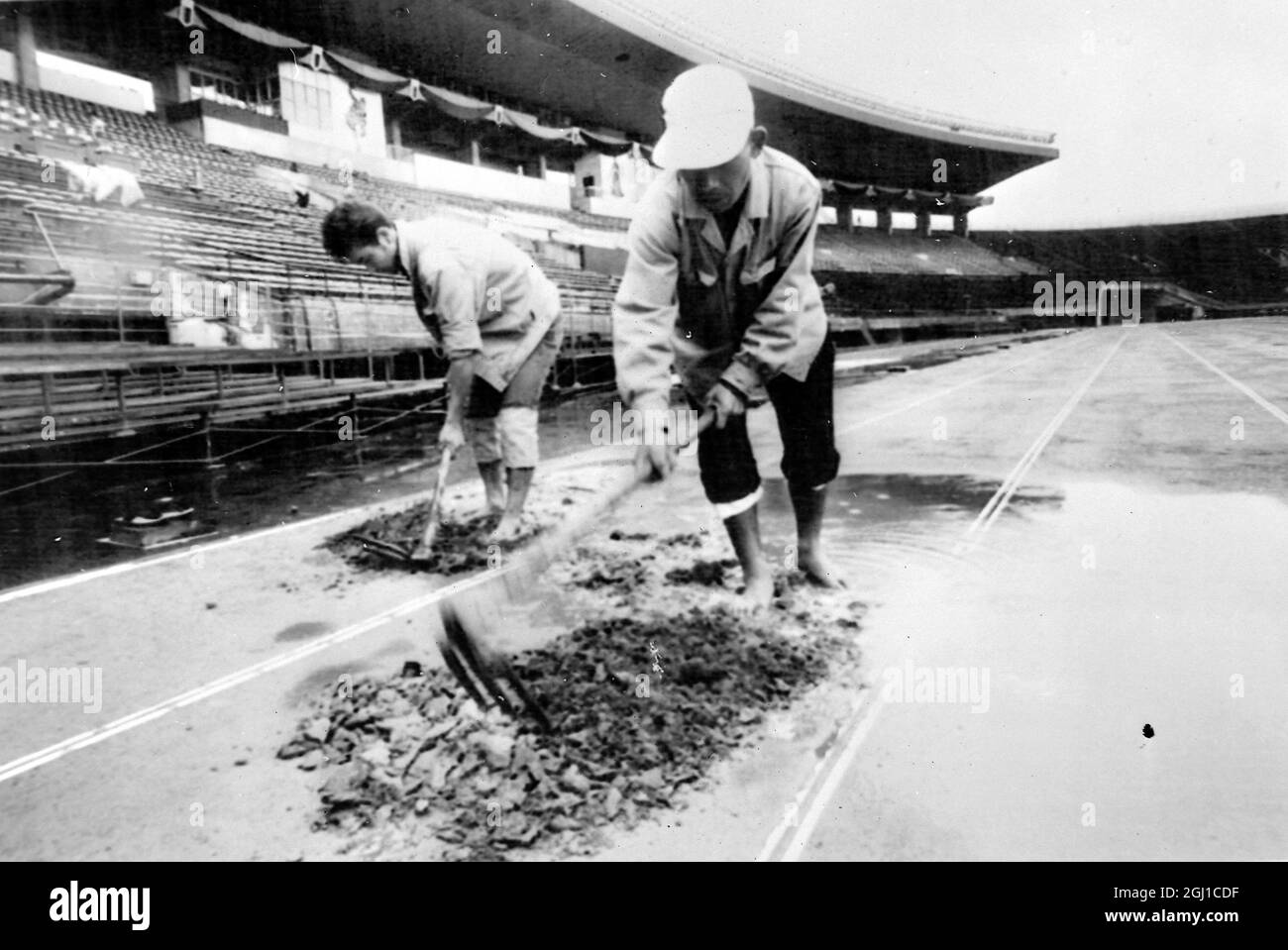 JEUX OLYMPIQUES, JEUX OLYMPIQUES DE SPORT - LA XVIII 18E OLYMPIADE À TOKYO, JAPON - STADES STADE NATIONAL TOKYO LES OUVRIERS CREUSENT UN TROU AQUATIQUE SUR LA PISTE ; 9 OCTOBRE 1964 Banque D'Images