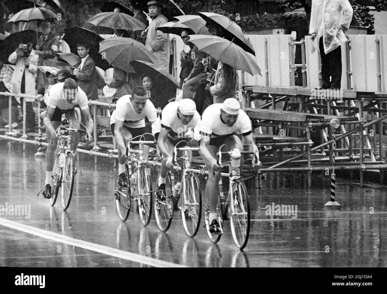 JEUX OLYMPIQUES, JEUX OLYMPIQUES DE SPORT - LA XVIII 18E OLYMPIADE À TOKYO, JAPON - JEUX OLYMPIQUES DE VÉLO L'ÉQUIPE ALLEMANDE PÉDALANT PAR LA PLUIE ; 15 OCTOBRE 1964 Banque D'Images