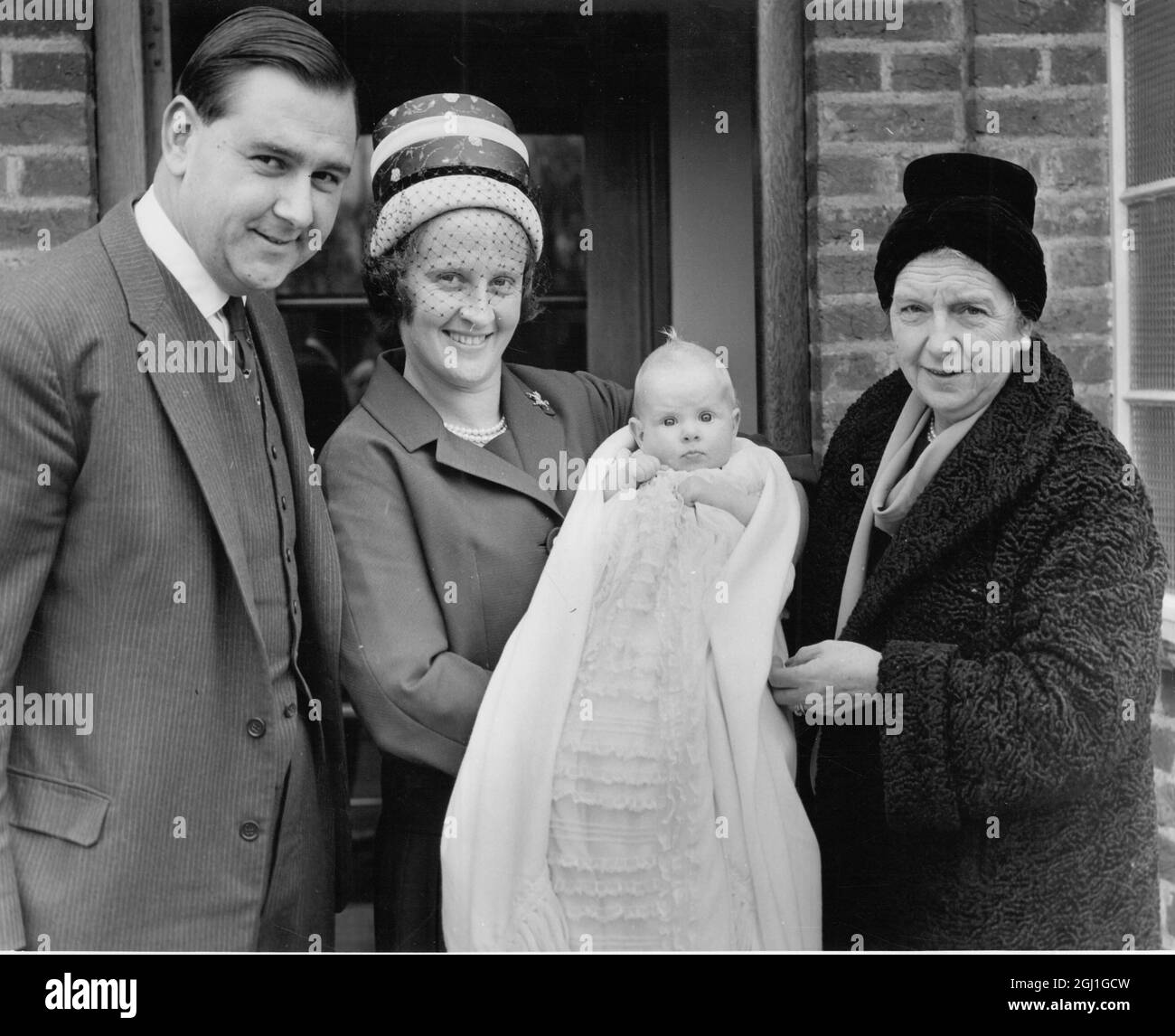 Troisième enfant de Colin Cowdrey une fille Carolyn Susan dans des robes de baptême détenues par la mère Penny Chiesman (avec une personne inconnue) 1962 Banque D'Images