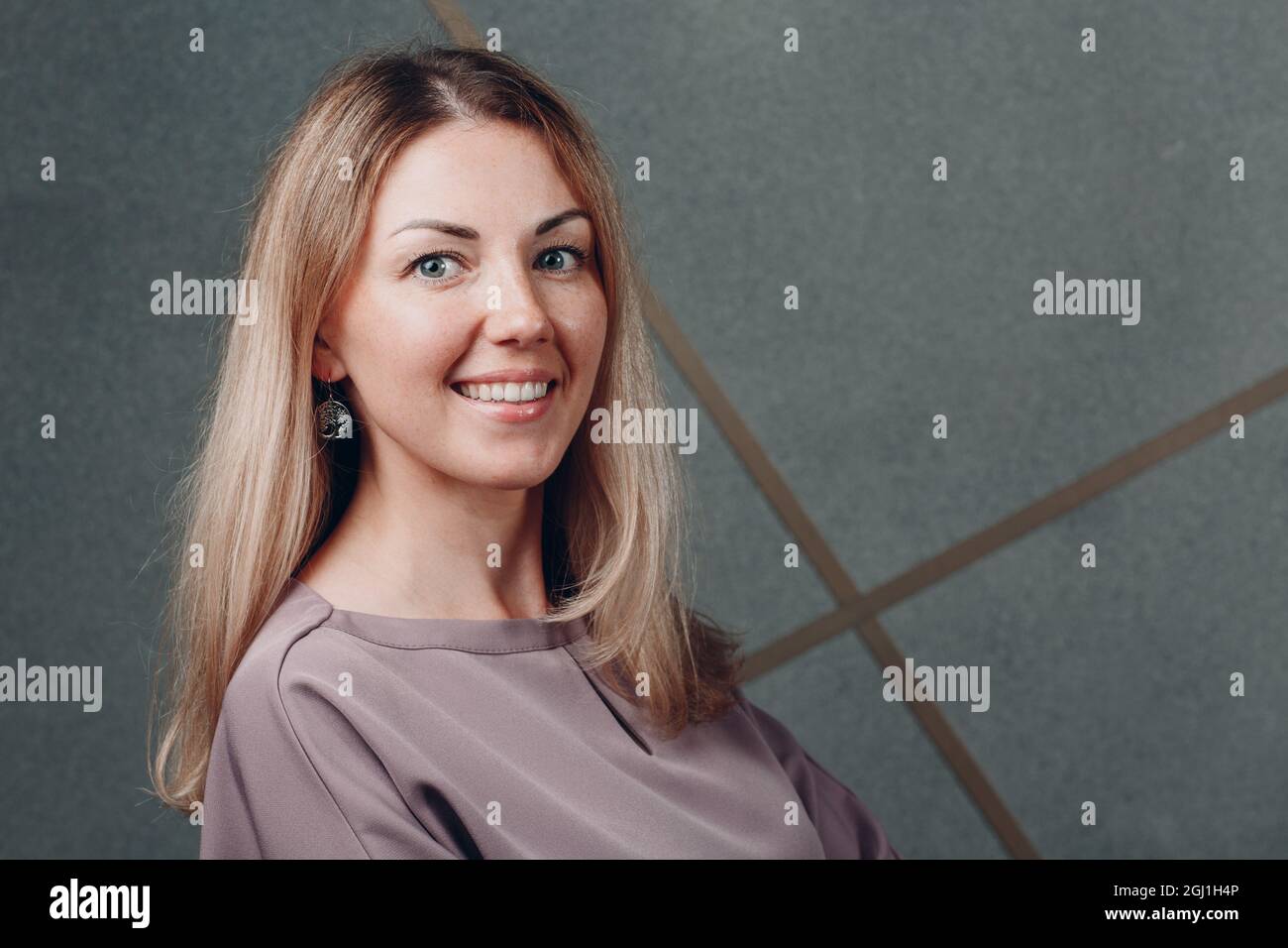 Jeune adulte caucasien européen blonde souriante femme demi-tour visage portrait Banque D'Images