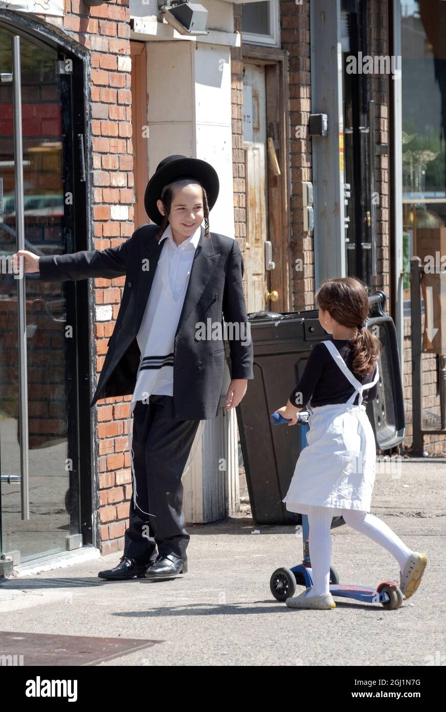FRÈRE, SŒUR ET SCOOTER. Un bon moment de frère sur Lee Avenue à Williamsburg, Brooklyn, New York. Banque D'Images