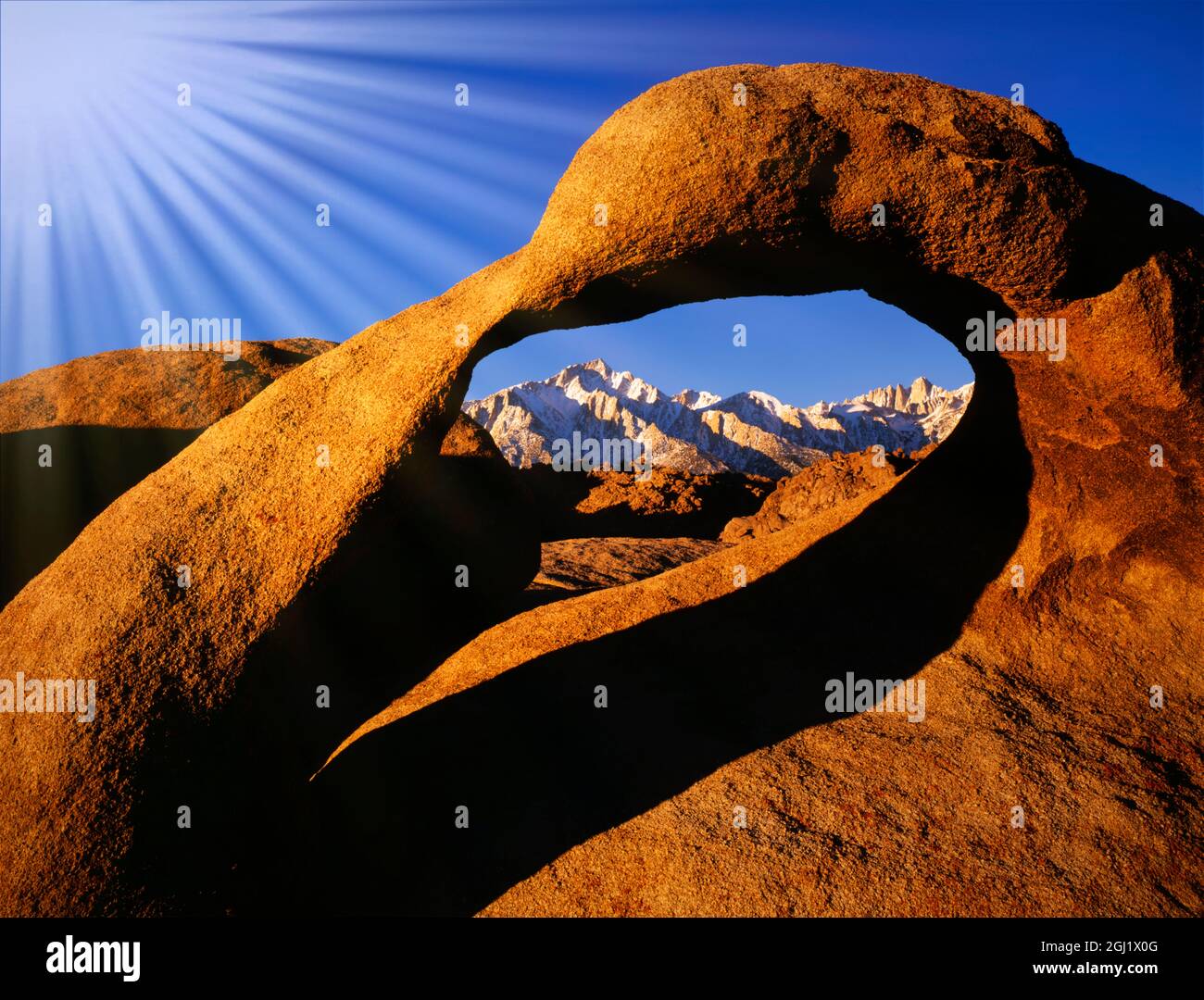 États-Unis, Californie, Alabama Hills. Rayons du soleil et arc en granit qui encadrent Lone Pine Peak. Banque D'Images