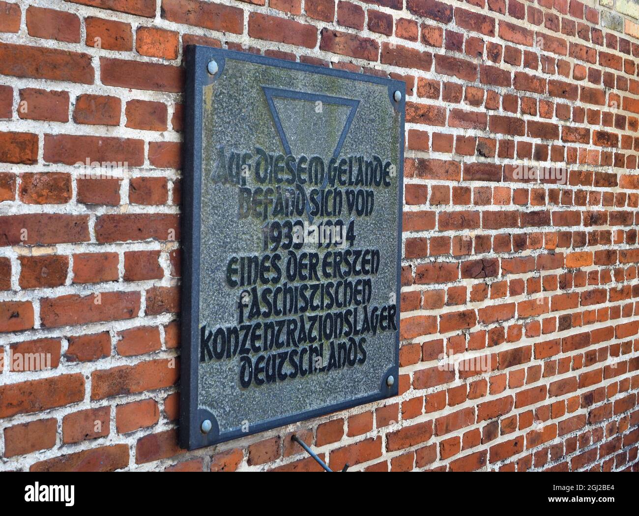 08 septembre 2021, Brandebourg, Oranienburg: Une plaque portant l'inscription 'l'un des premiers camps de concentration fasciste d'Allemagne a été situé sur ce site de 1933 à 1934' est apposée sur un mur de briques sur la Berliner Straße. En mars 1933, la sa locale avait établi le premier camp de concentration de Prusse dans l'ancienne brasserie Kindl. Jusqu'à la fermeture du camp en juillet 1934, environ 3000 prisonniers d'Oranienburg et des environs ainsi que de Berlin ont été internés ici. Au moins 16 des prisonniers sont morts dans le camp de concentration d'Oranienburg, dont l'écrivain Erich Mühsam. Le site commémoratif est Banque D'Images