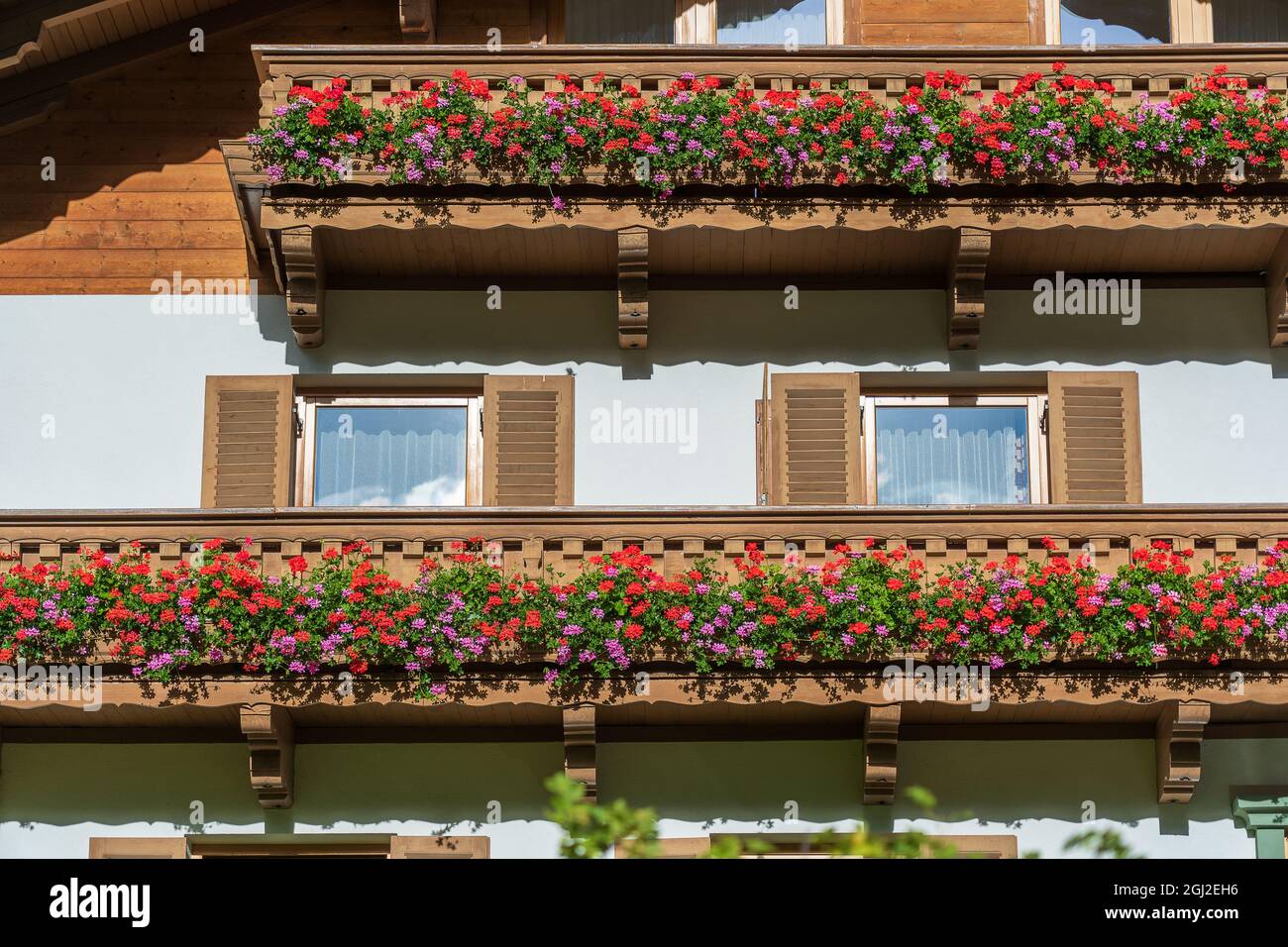 Le balcon en bois d'une ancienne ferme de montagne avec des fleurs colorées en Autriche, gros plan Banque D'Images