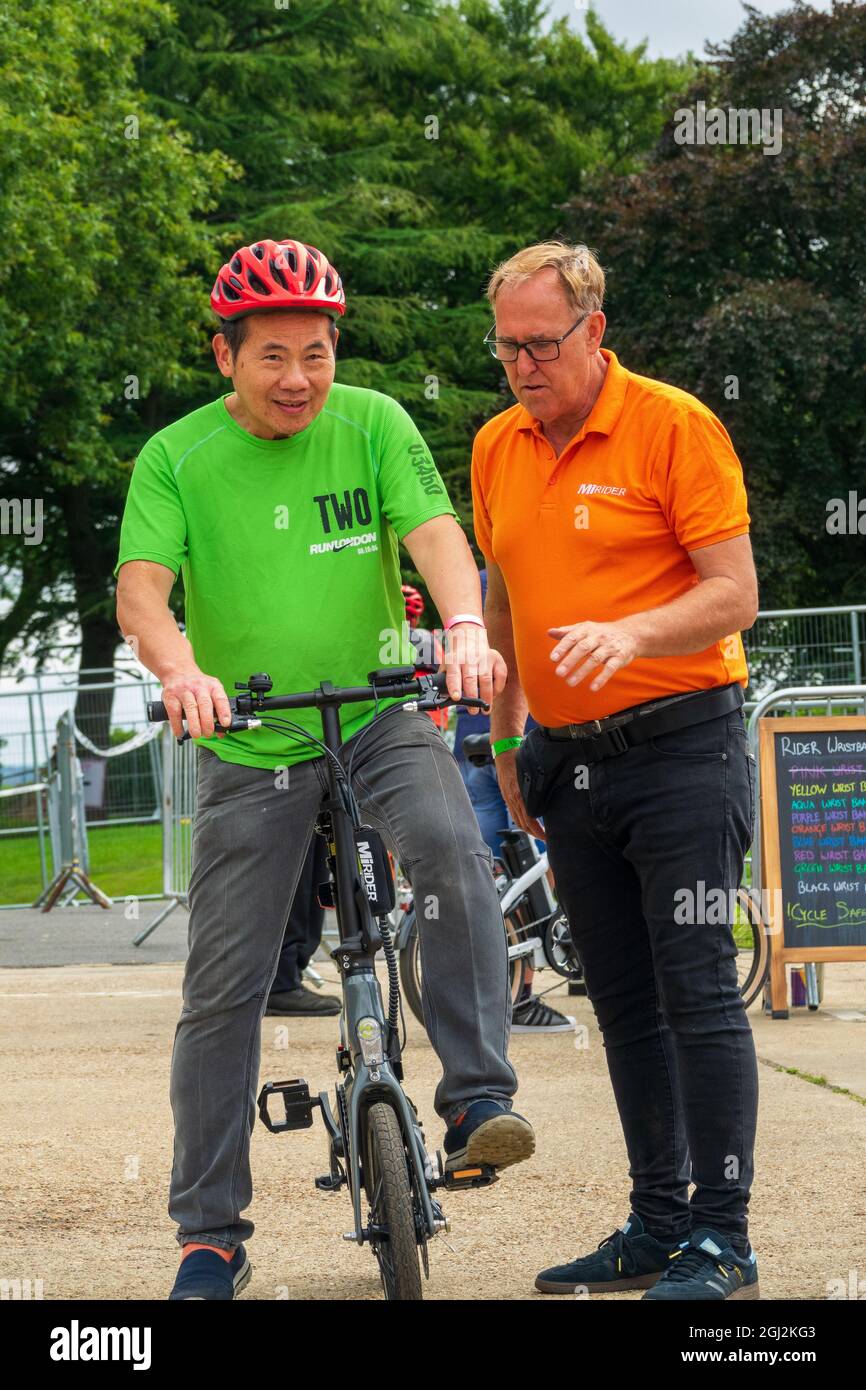 LONDRES, ROYAUME-UNI - 15 août 2021 : le cycliste avec casque testant un vélo électrique lors du week-end de démonstration du cycle E-Bike à Londres Banque D'Images