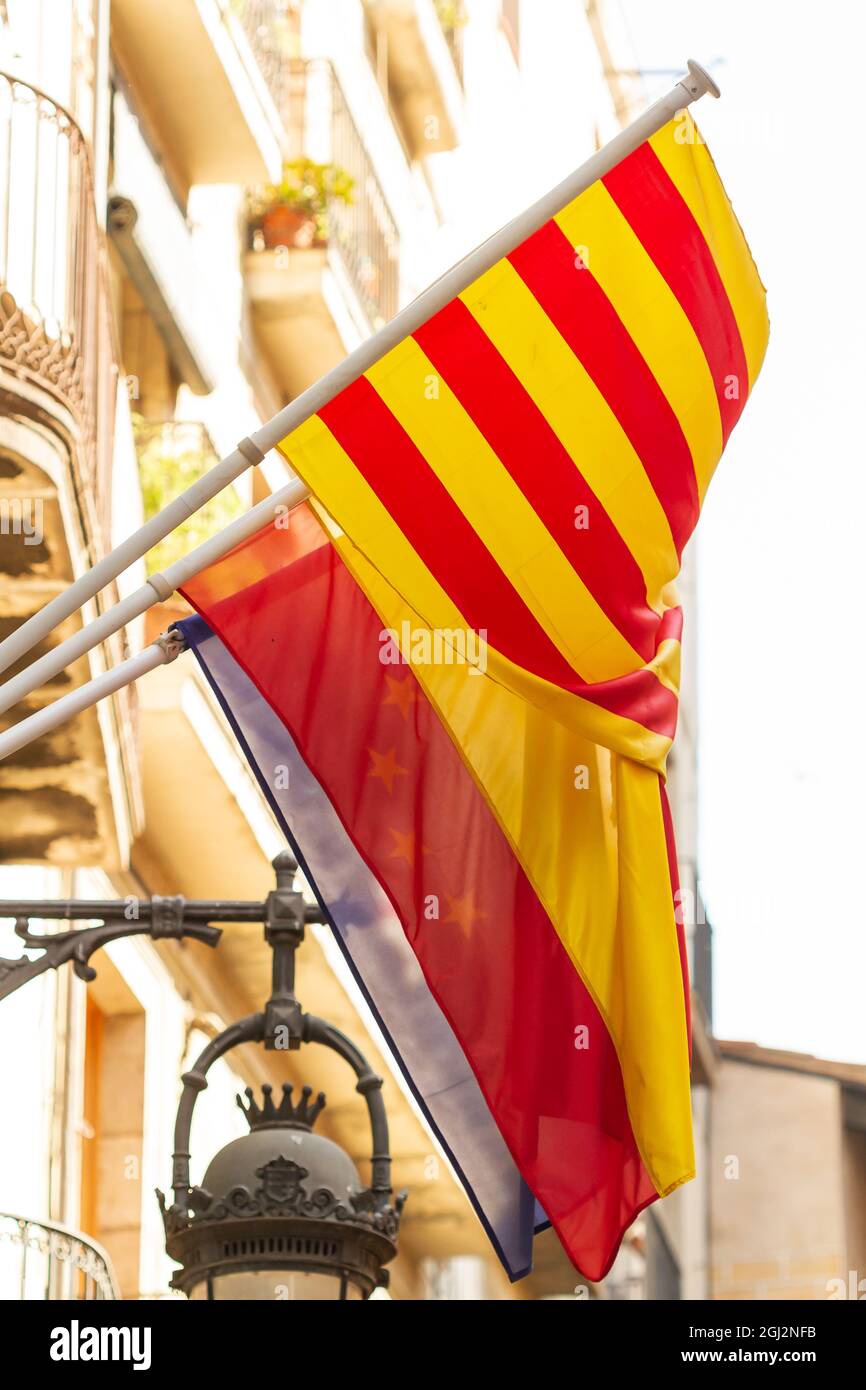 Gros plan vertical des drapeaux catalanes et espagnols suspendus Banque D'Images