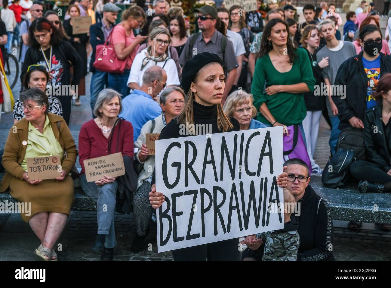 Cracovie, Pologne. 3 septembre 2021. Les manifestants tiennent des pancartes exprimant leur opinion pendant la manifestation.les manifestants ont manifesté contre l'introduction de l'état d'urgence sur la frontière biélorusse polonaise, sur la place principale inscrite au patrimoine mondial de l'UNESCO à Cracovie. Le gouvernement de la Pologne a instauré un état d'urgence dans deux régions limitrophes de la Biélorussie alors qu'un afflux de migrants du Moyen-Orient se produit. Pendant ce temps, plus de 30 000 personnes en provenance d'Afghanistan ont été coincées pendant plus de trois semaines entre les gardes biélorusses armés d'un côté et les forces polonaises armées de l'autre. Certains sont malades comme le Banque D'Images