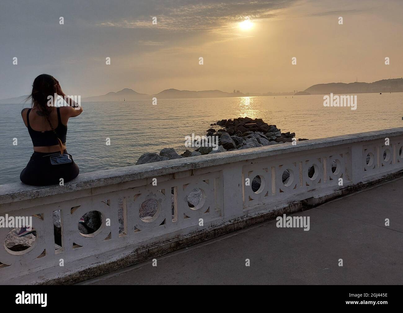 Santos, Sao Paulo, Brésil. 8 septembre 2021. (INT) les baigneurs regardent le coucher du soleil sur la plage de Santos. 8 septembre 2021, Santos, Sao Paulo, Brésil: Les baigneurs regardent le coucher de soleil sur le mur bas de Ponta da Praia, à Santos, sur la côte sud de Sao Paulo, le mercredi (8), un congé municipal en l'honneur de Nossa Senhora do Monte Serrat, patron de la ville. (Credit image: © Luigi Bongiovanni/TheNEWS2 via ZUMA Press Wire) Banque D'Images