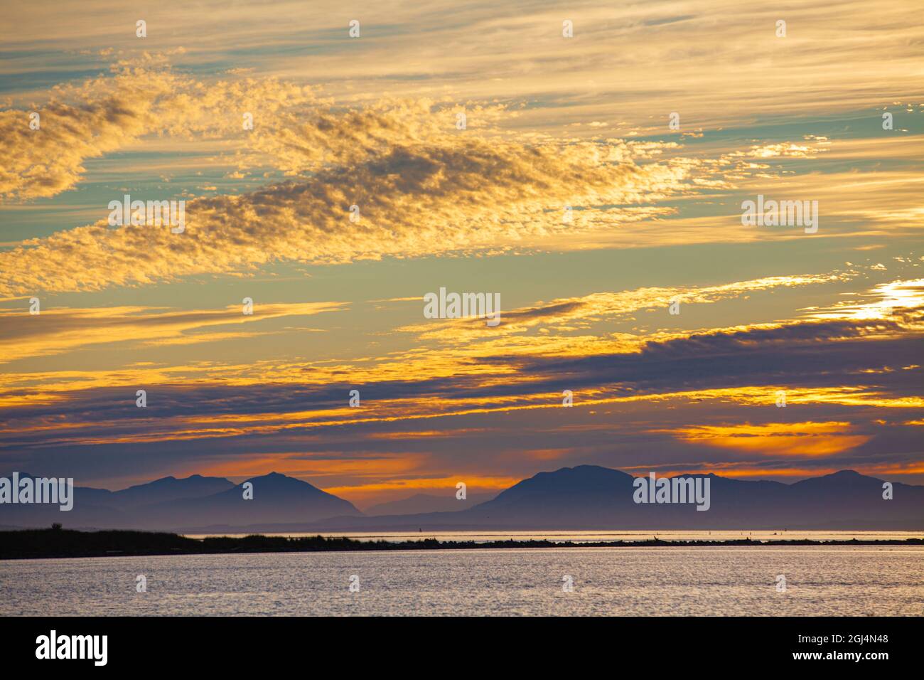 Une vue lointaine sur les montagnes de l'île de Vancouver, de l'autre côté du détroit de Georgia, depuis Steveston, en Colombie-Britannique, au Canada Banque D'Images