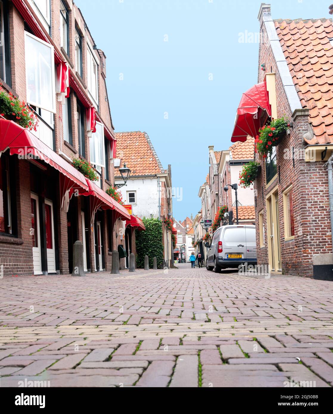 Alkmaar pays-Bas - août 18 2012 ; rue pavée pittoresque et calme avec des bâtiments en briques et en tuiles avec des canopies rouges. Banque D'Images