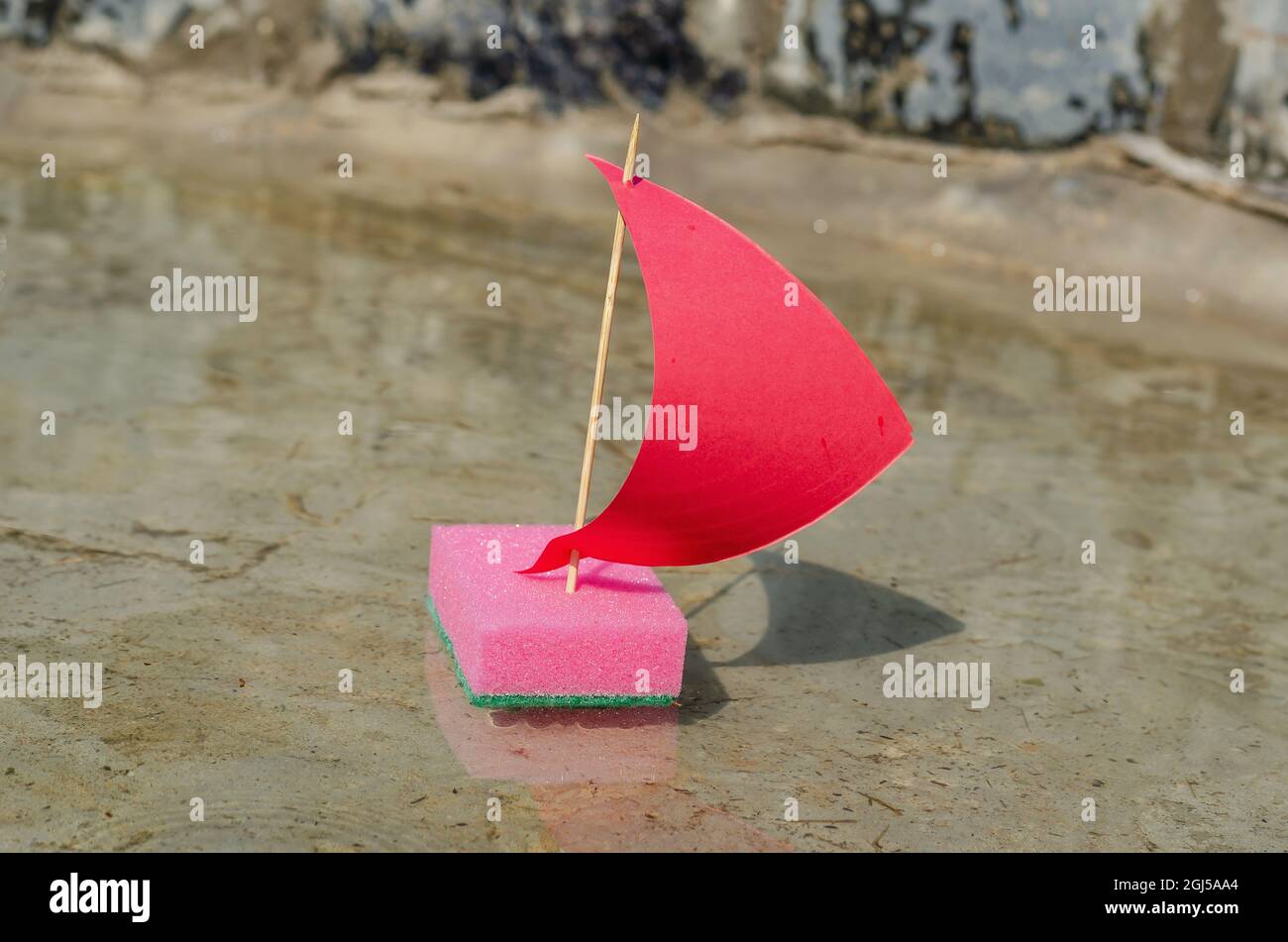 Bateau à voile Pink Toy naviguant sur l'eau claire. Un navire de cuisine Banque D'Images