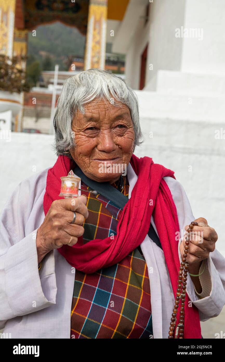 Bhoutan, Thimphu, National Memorial Chorten, alias Thimphu Stupa. Vieille femme en tenue traditionnelle avec roue de prière. (Usage éditorial uniquement) Banque D'Images