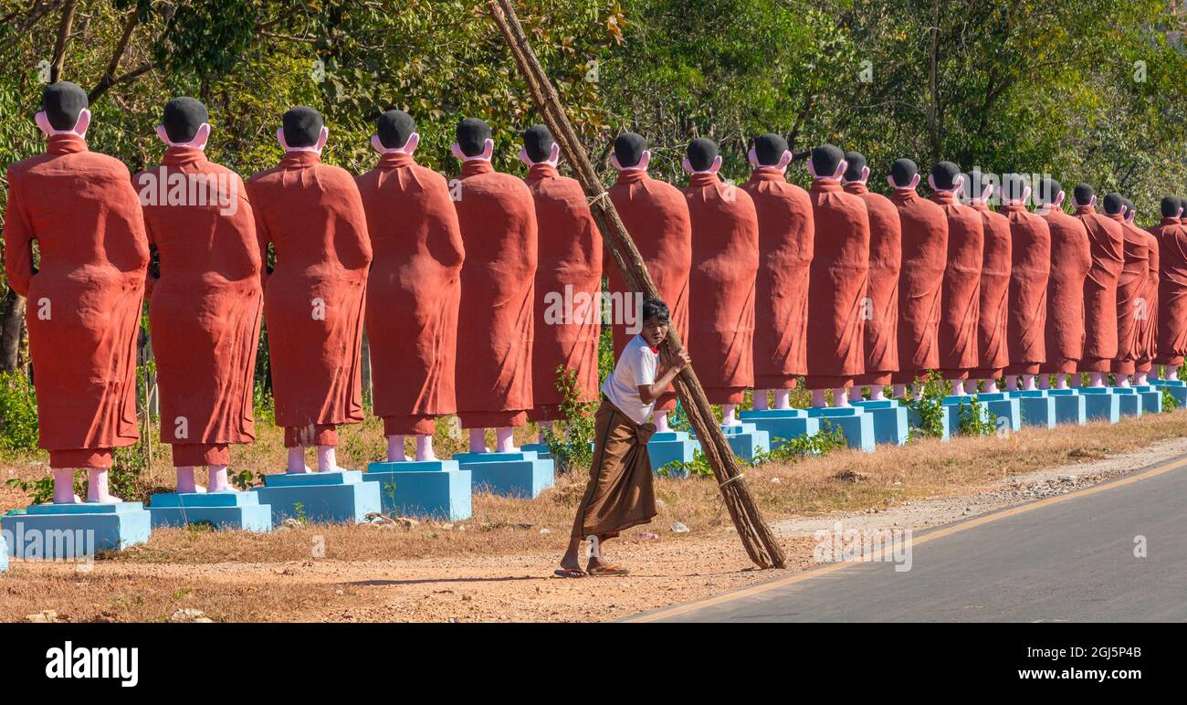 Homme portant le bois et la figure de bouddha Banque D'Images
