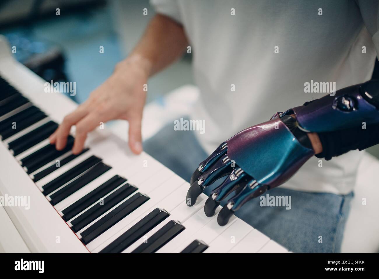 Jeune homme handicapé jouant sur un synthétiseur électronique de piano avec  une main artificielle prothétique dans un magasin de musique Photo Stock -  Alamy