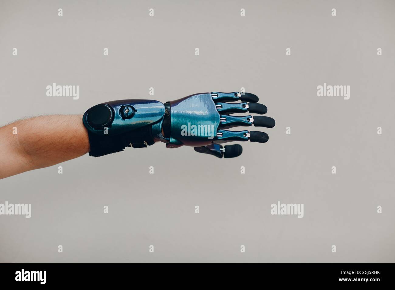 Homme handicapé avec une main prothétique artificielle gros plan de la main mâle sur fond gris Banque D'Images