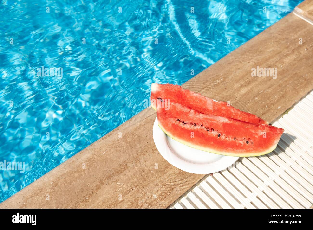 Pastèque fraîche au bord de la piscine. Voyage d'été chaud, vacances et concept de vacances. Vue de dessus. Espace de copie - image Banque D'Images