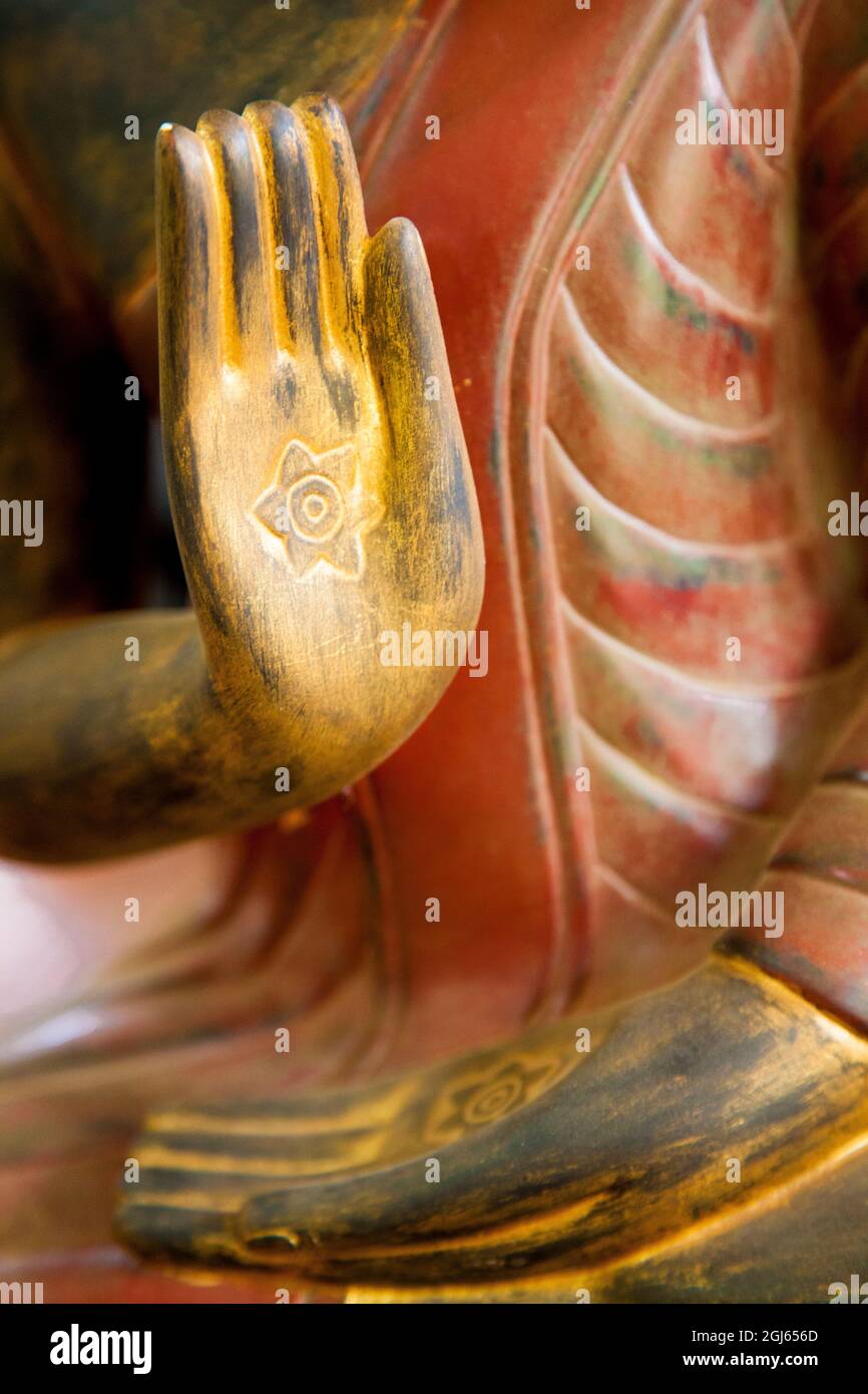 Cambodge, Siem Reap, mains dorées sur la statue de Bouddha en bois rouge. Banque D'Images