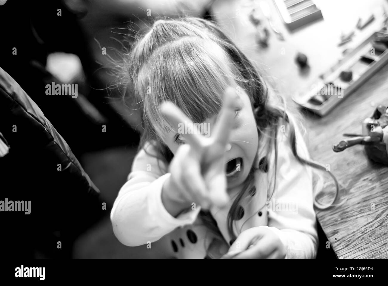 Une fille montre deux doigts d'une main.Focus sur la tête. Photo B W Banque D'Images