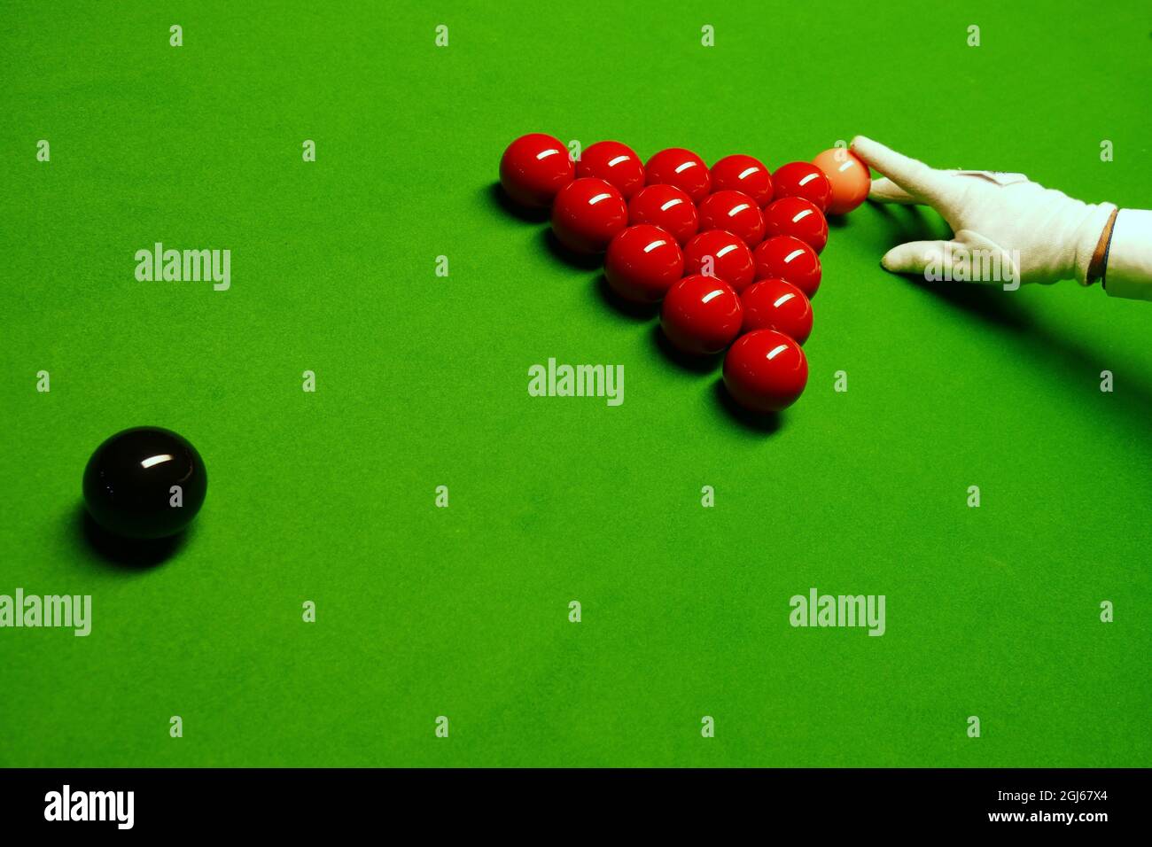 Gros plan des boules de billard sur la table avec une main dans un gant blanc. Banque D'Images