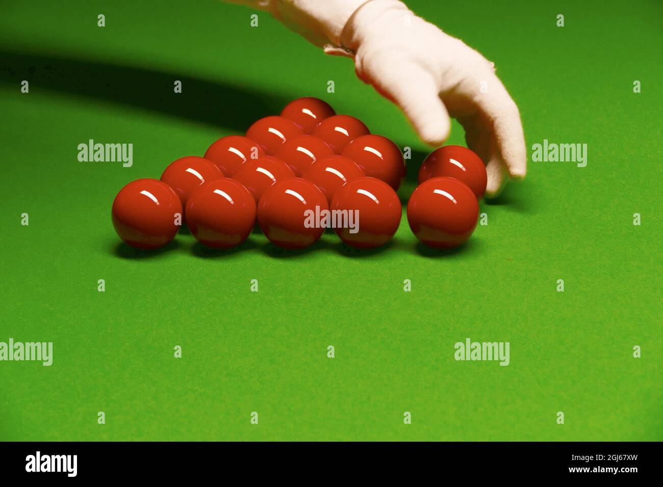 Gros plan des boules de billard sur la table avec une main dans un gant blanc. Banque D'Images