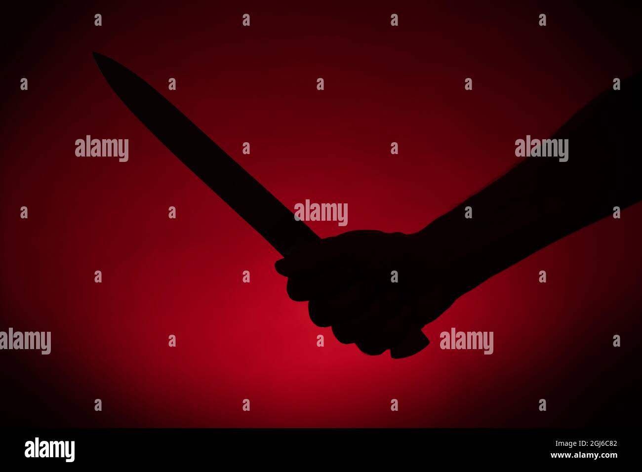 Main avec une silhouette de couteau sur fond rouge. Halloween et violence concept Banque D'Images