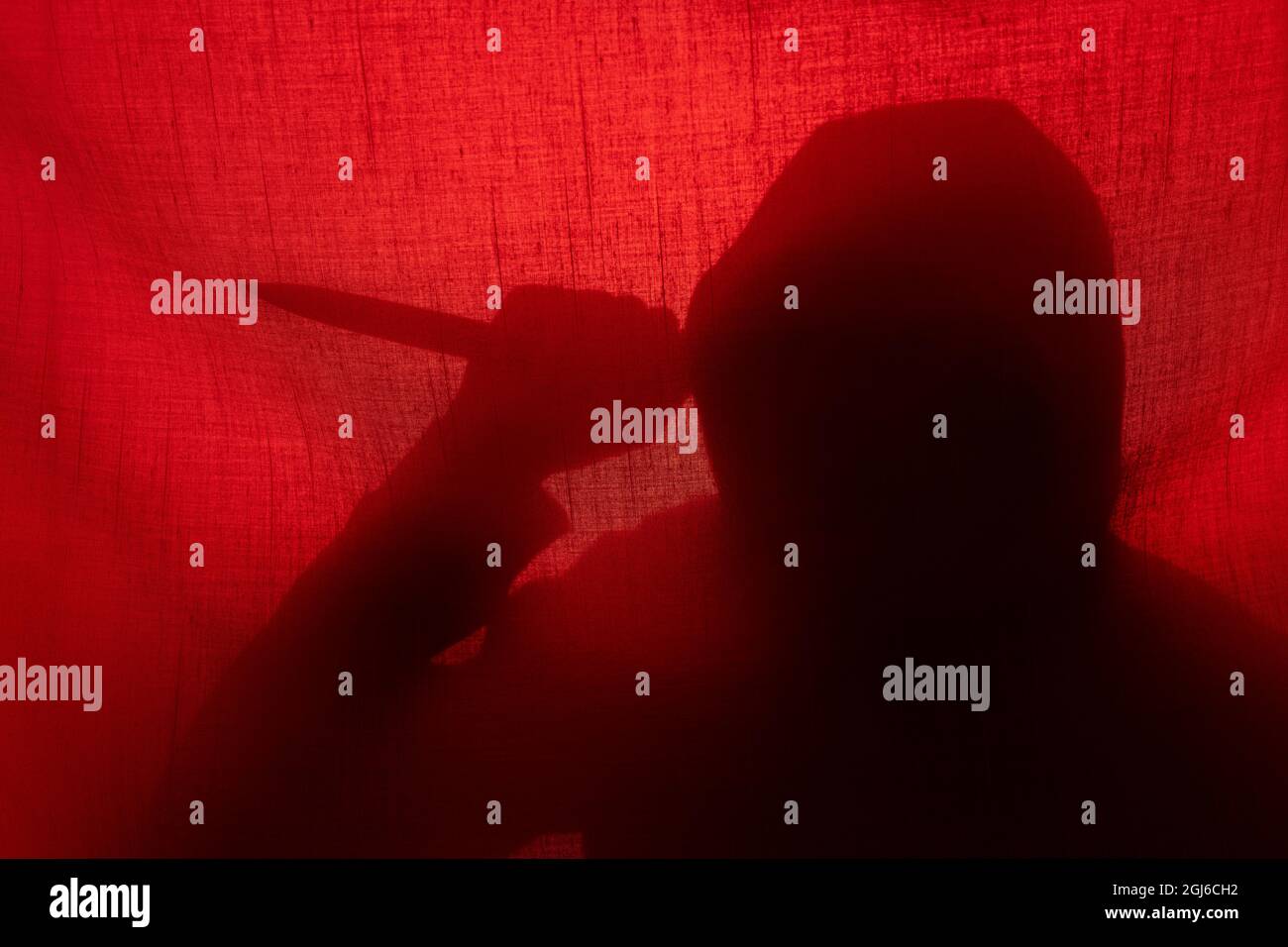Homme avec une silhouette de couteau derrière un rideau. Halloween et violence concept Banque D'Images