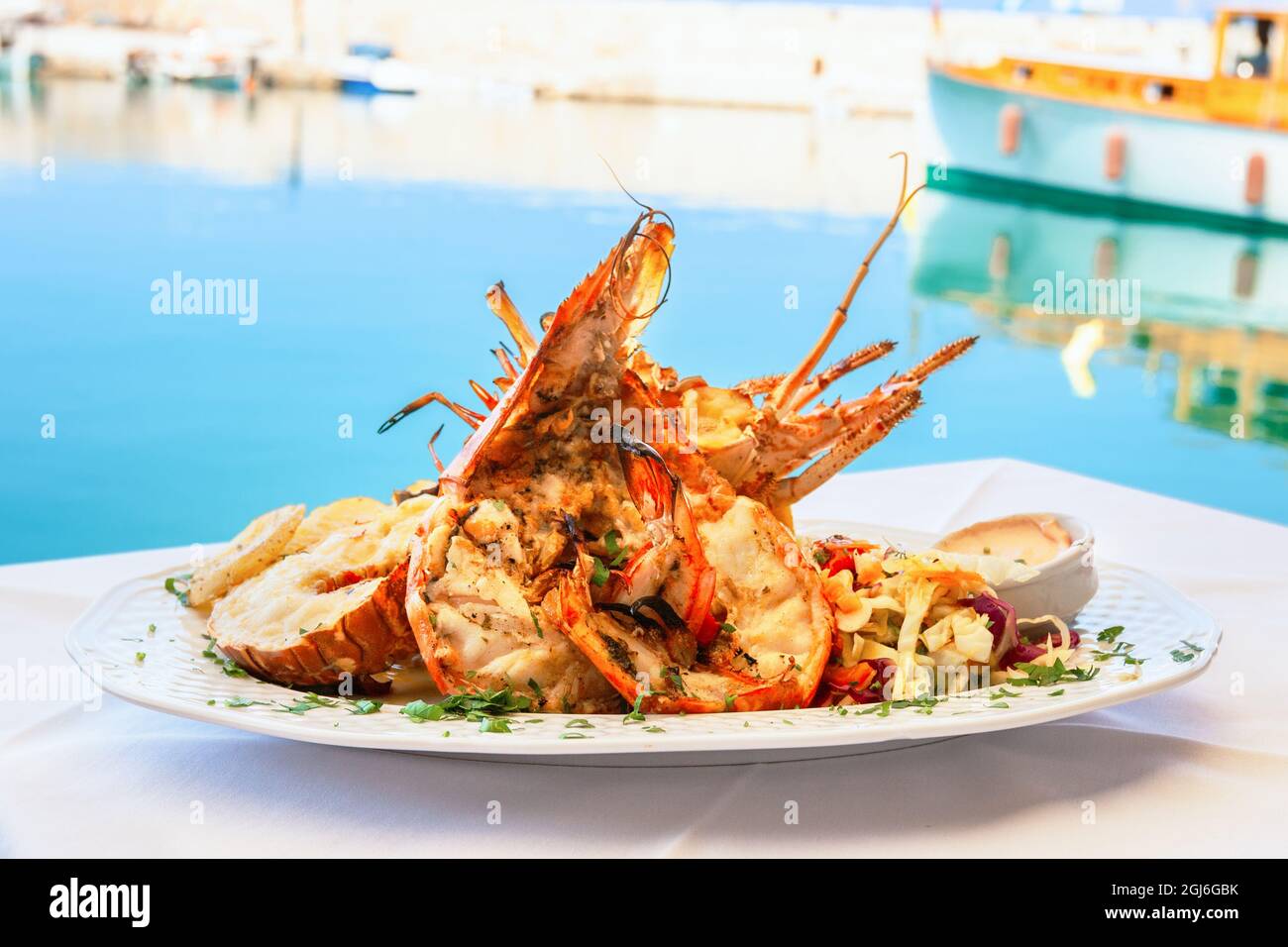 Un plat traditionnel de homard est servi à la taverne en bord de mer de Rethymno. Crète, Grèce Banque D'Images