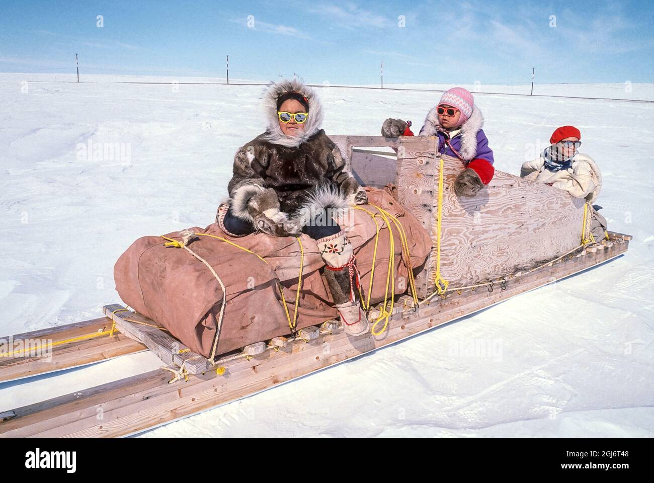 Baker Lake, Nunavut, Canada. Les jeunes filles inuites locales de 11 et 4 ans, vêtues de vêtements traditionnels en peau de caribou, ainsi que la femme aînée, assise sur un tradi Banque D'Images