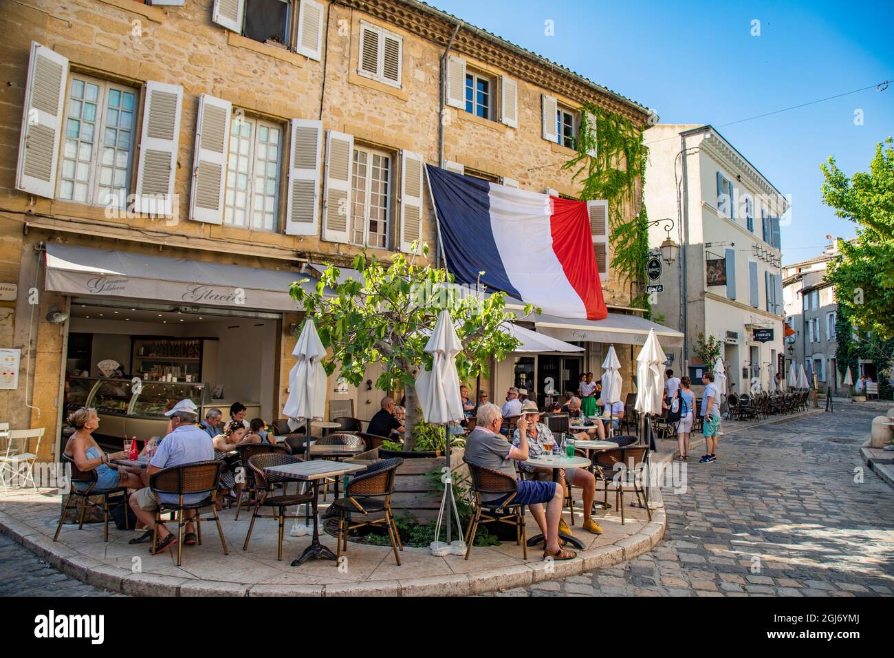 Petits cafés de village français avec drapeau français en Provence dans le sud de la France. Banque D'Images