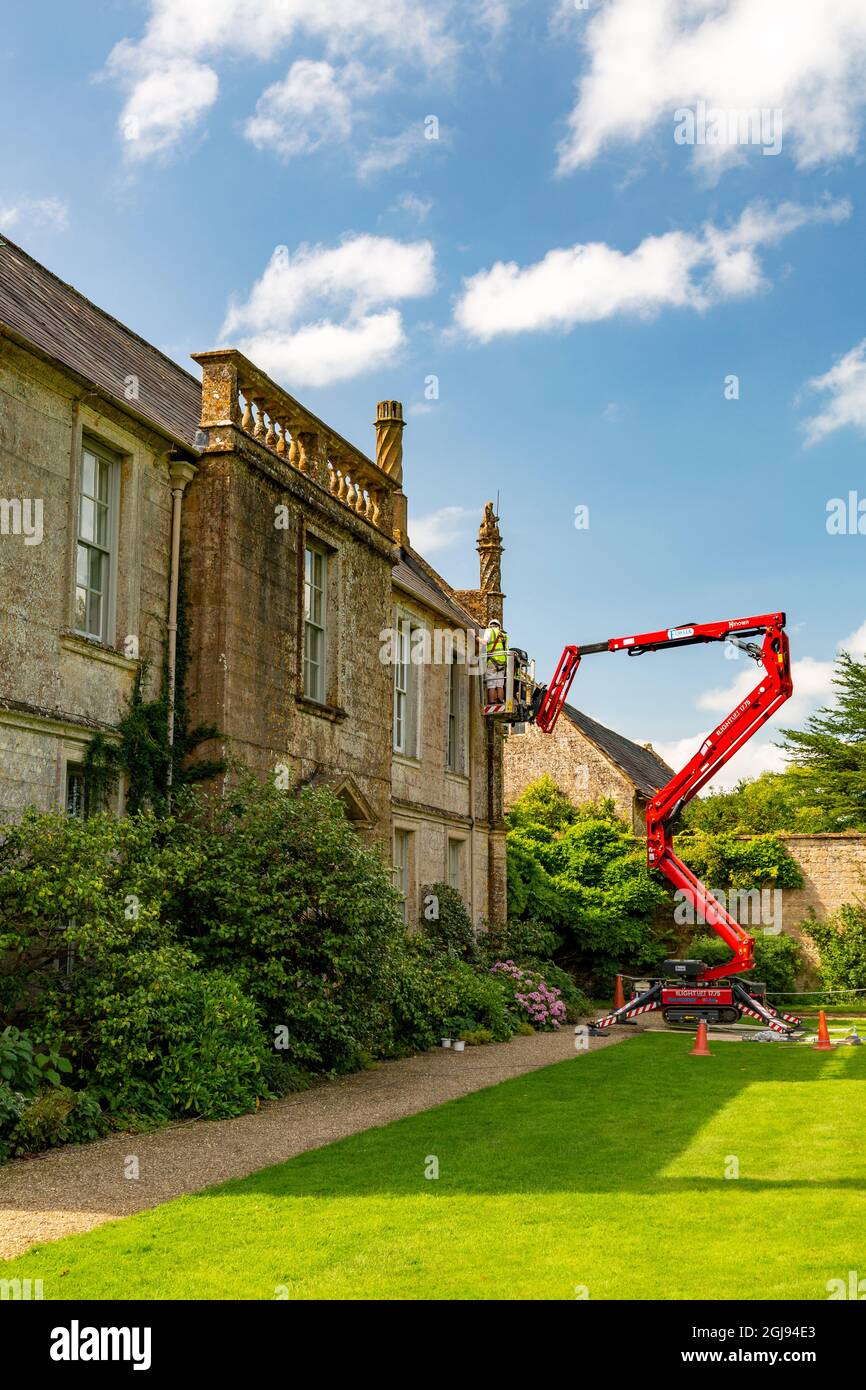 Entretien du tissu extérieur du bâtiment à l'aide d'un préparateur de cerises et d'échelles à la maison historique Jacobean Mapperton House, Dorset, Angleterre, Royaume-Uni Banque D'Images