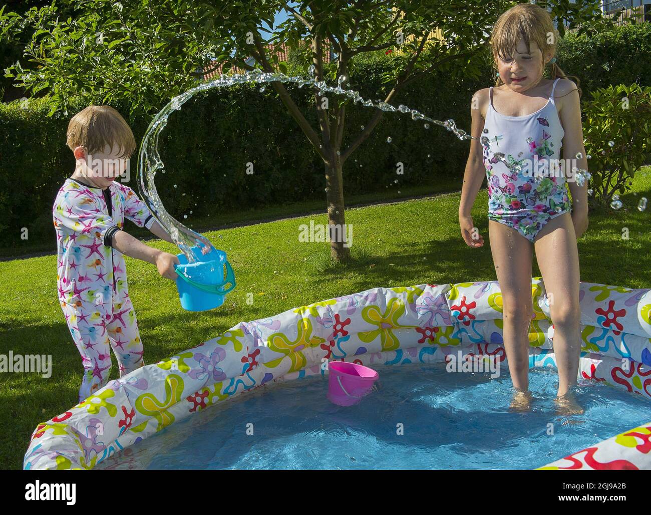 STOCKHOLM 2015-07-03 Elvina, 6 ans et Melcher, 3 ans s'amusent dans la piscine dans leur jardin à Stockholm, Suède 3 juillet 2015. Les Suédois prennent toutes les chances de se refroidir à mesure que leur température atteint 30 degrés Celsius. Foto Jonas Ekstromer / TT / Kod 10030 Banque D'Images