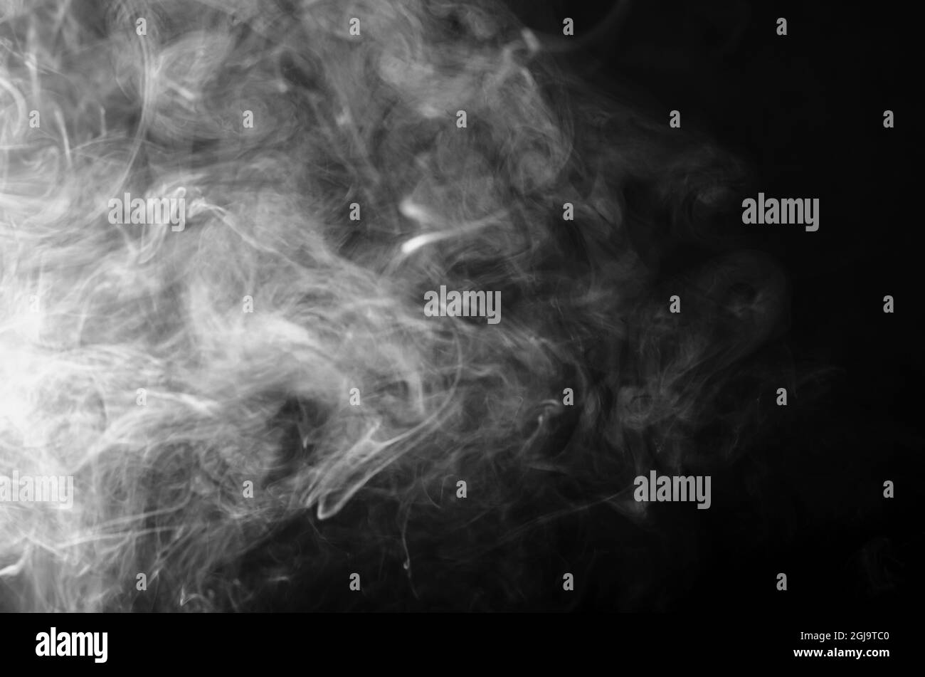 Blanc, vagues grises de fumée, trace de glace sèche, vapeur, encens sur fond noir. Nuage de fumée de cigarette Banque D'Images