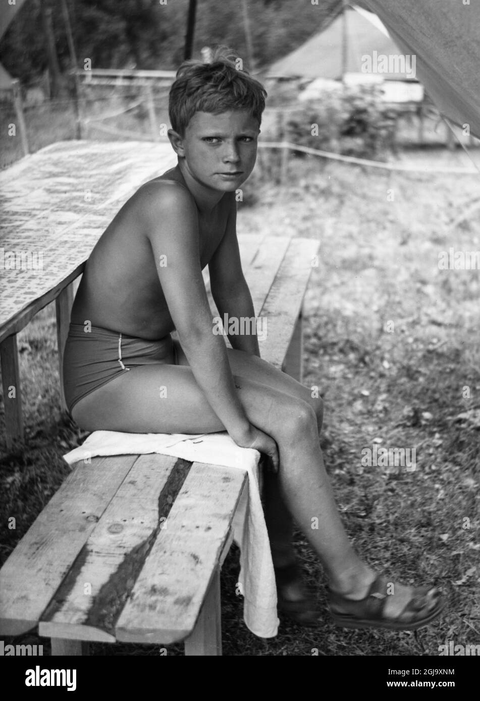 Texte bildtext orig.... 'TAGGEN', LE SCOUT ROYAL... Septembre 1959. L'été est parti et aujourd'hui notre prince héritier, H.R.H. Carl Gustaf, est occupé avec ses tâches au collège Sigtuna où il a commencé son premier mandat cet automne. Mais le long été chaud est un souvenir à garder pour un garçon de treize ans et le prince héritier se souviendra sûrement avec joie des jours heureux qu'il a apprécié comme scout sur un camp de scouts de garçon sur l'île de Galo dans l'archipel Stockholmian. Ces photos montrant le prince héritier comme un 'garçon parmi les garçons', juste un garçon commun, prêt pour le plaisir, pour le travail et le sport, sont quelques-uns des plus inconv Banque D'Images