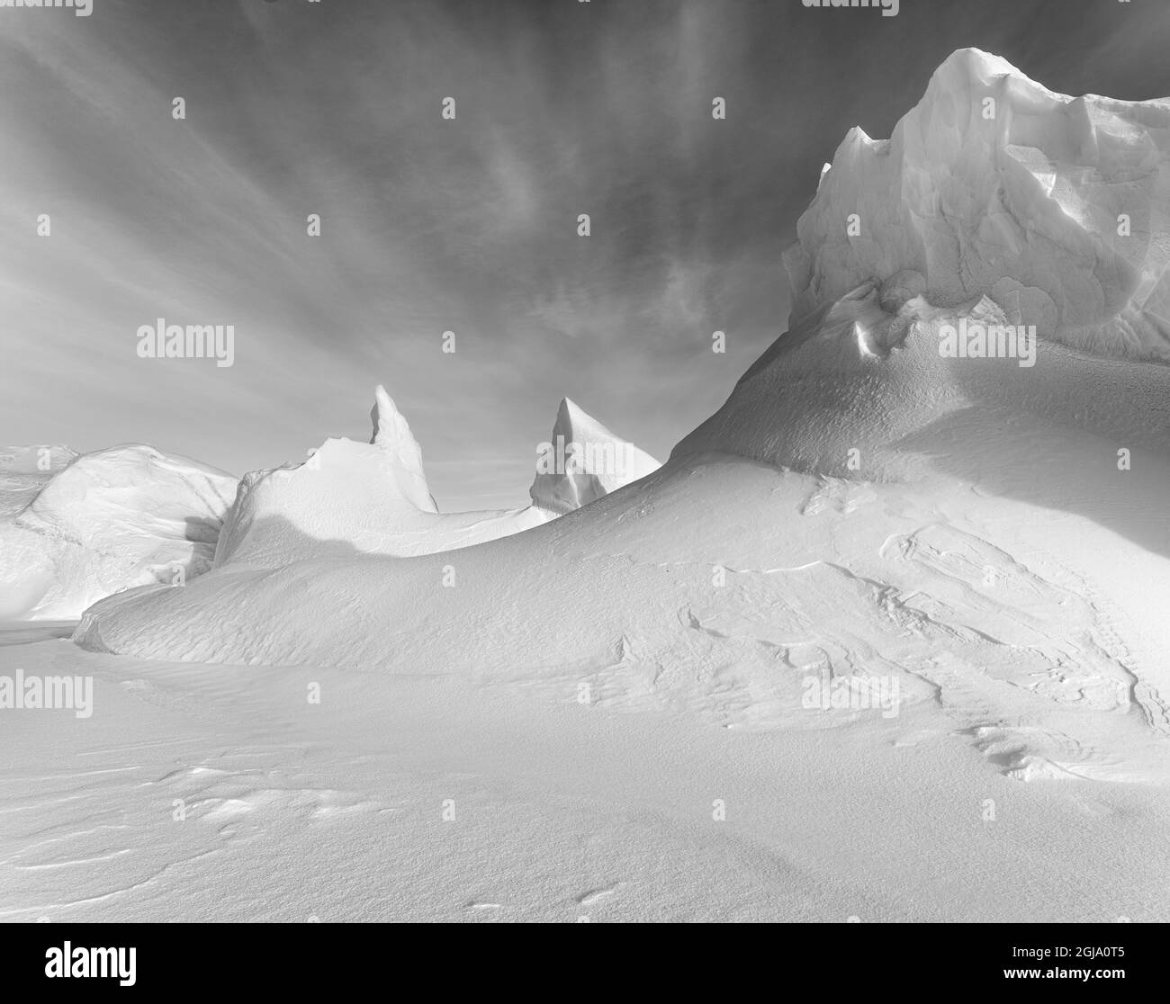 Iceberg gelé dans la glace de mer de la baie Melville, près de Kullorsuaq, à l'extrême nord de l'ouest du Groenland. Banque D'Images