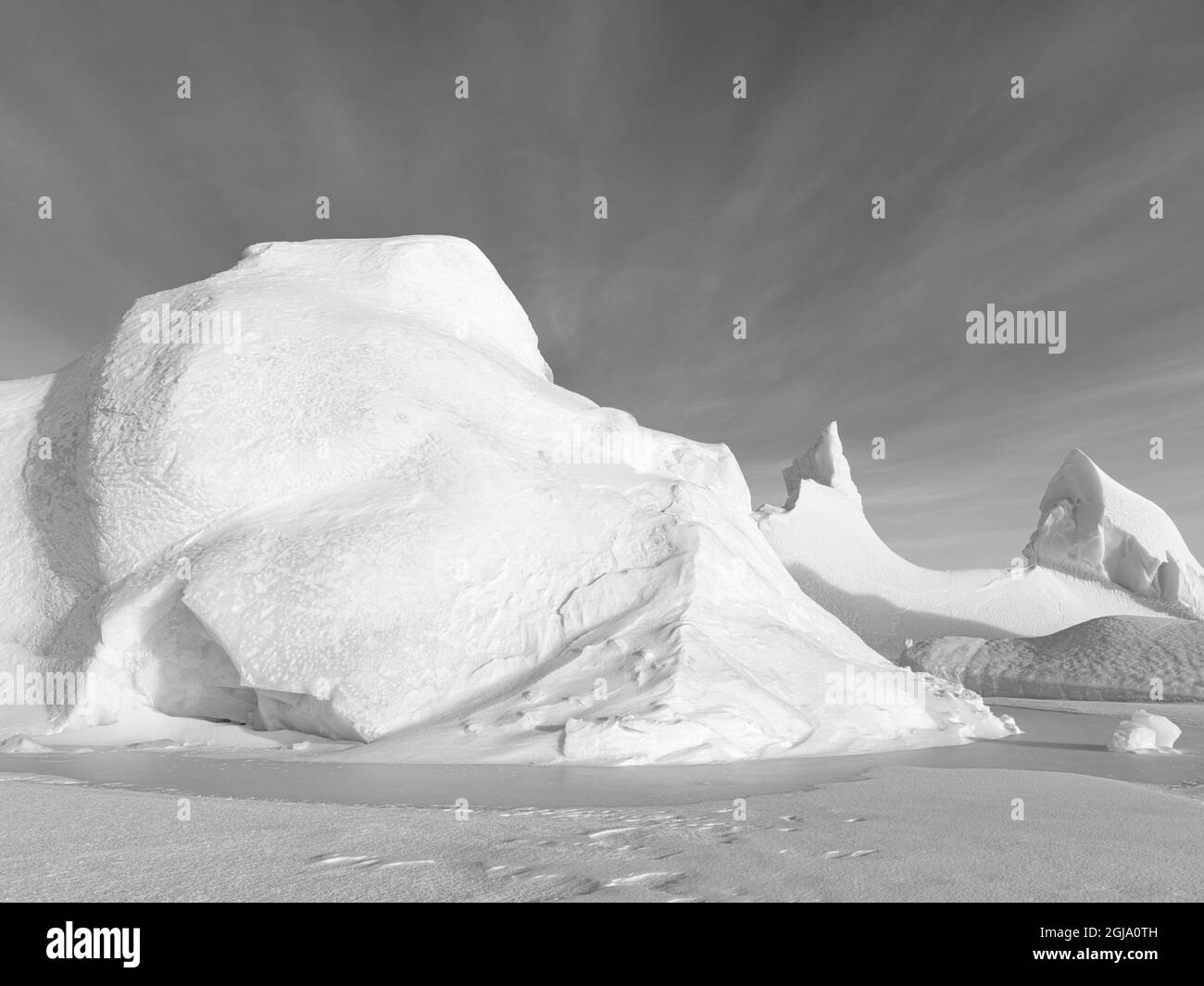 Iceberg gelé dans la glace de mer de la baie Melville, près de Kullorsuaq, à l'extrême nord de l'ouest du Groenland. Banque D'Images