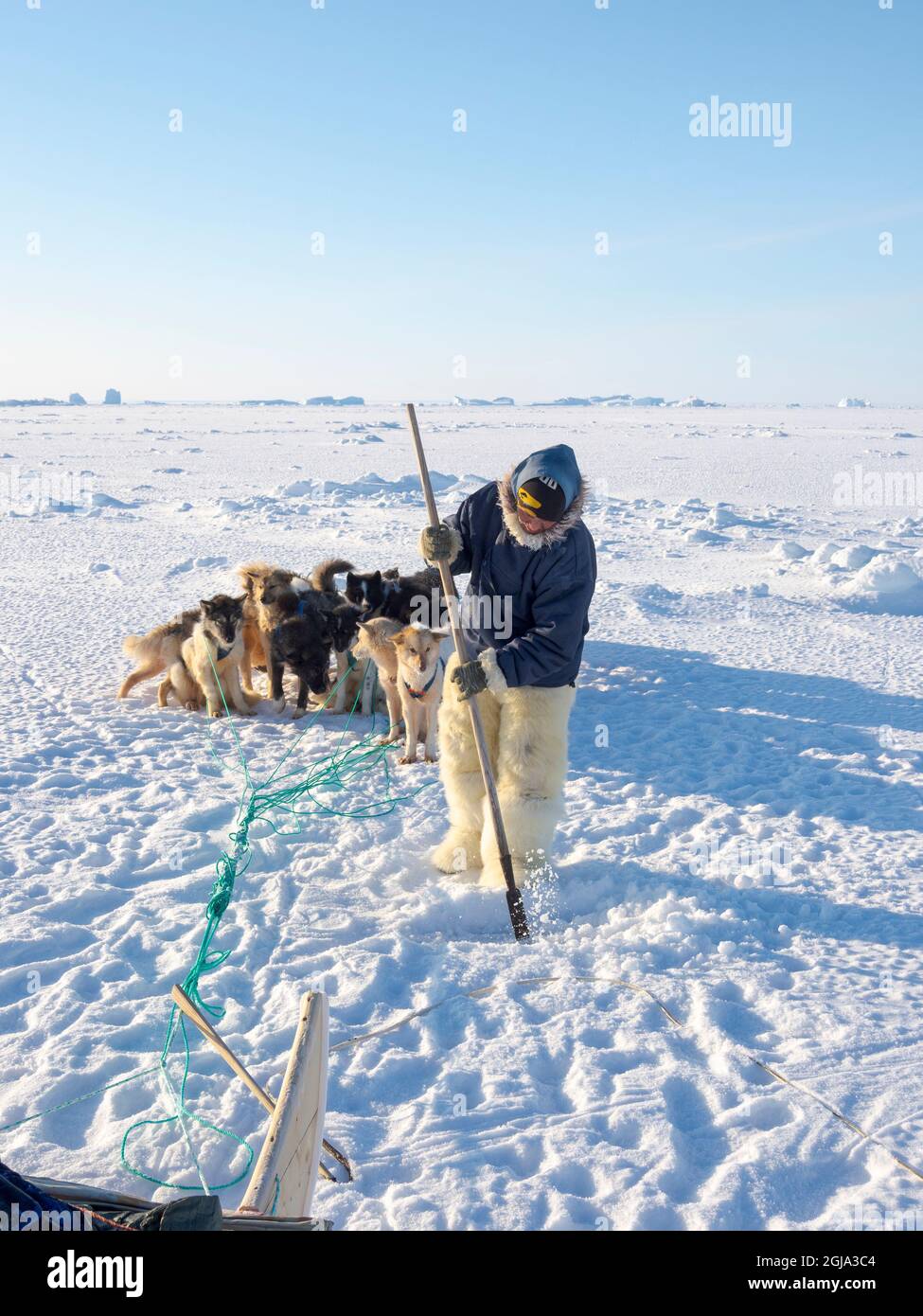 Chasseur inuit portant des pantalons traditionnels et des bottes