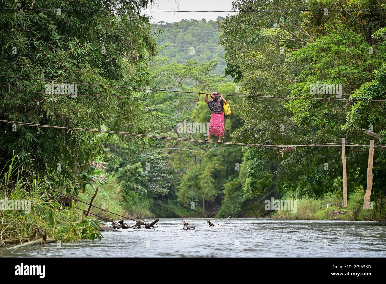 Luwu, Indonésie. 09e septembre 2021. Un résident traverse une rivière en utilisant un pont gravement endommagé à Malela.même si c'est dangereux, chaque jour le pont qui a été endommagé par l'inondation est encore utilisé par les résidents pour réduire le temps de voyage vers d'autres villages. Crédit : SOPA Images Limited/Alamy Live News Banque D'Images