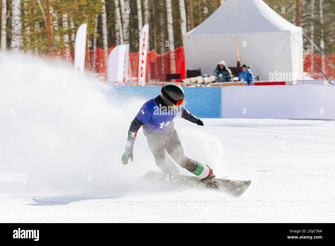 Le snowboard italien ralentit dans la ligne d'arrivée derrière elle des éclaboussures de neige Banque D'Images