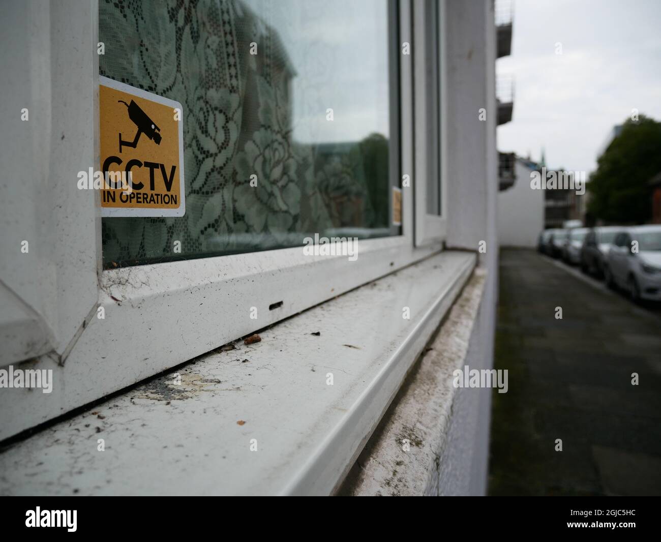 Panneau d'avertissement de mise en service de vidéosurveillance dans la fenêtre de la maison du centre-ville Banque D'Images