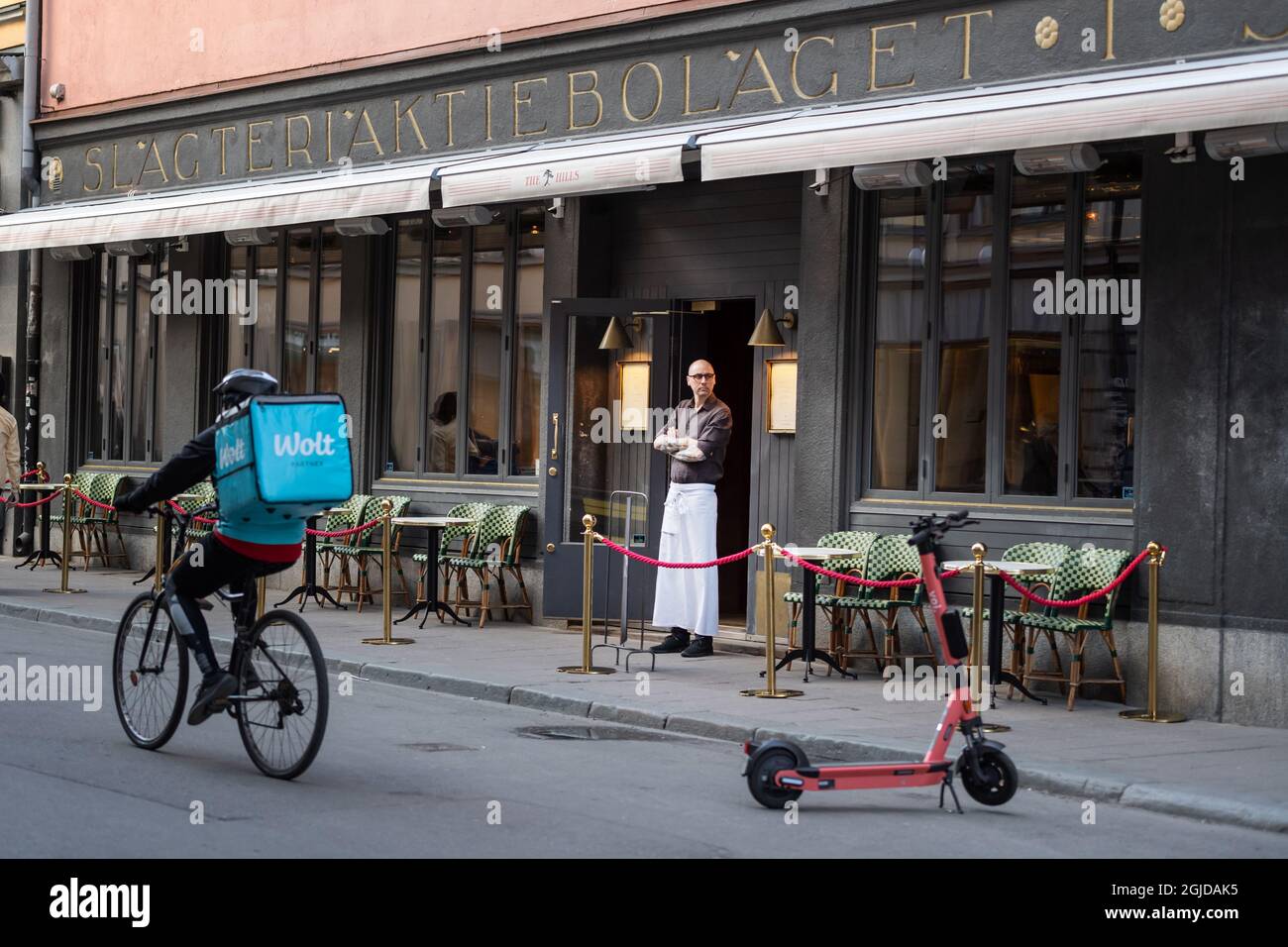 Un serveur donne sur un restaurant tandis qu'un préposé à la livraison de nourriture passe à son vélo à Stockholm, Suède, le 17 avril 2020. Photo: Stina Stjernkvist / TT Kod 11610 ***OUT SUÈDE OUT *** Banque D'Images