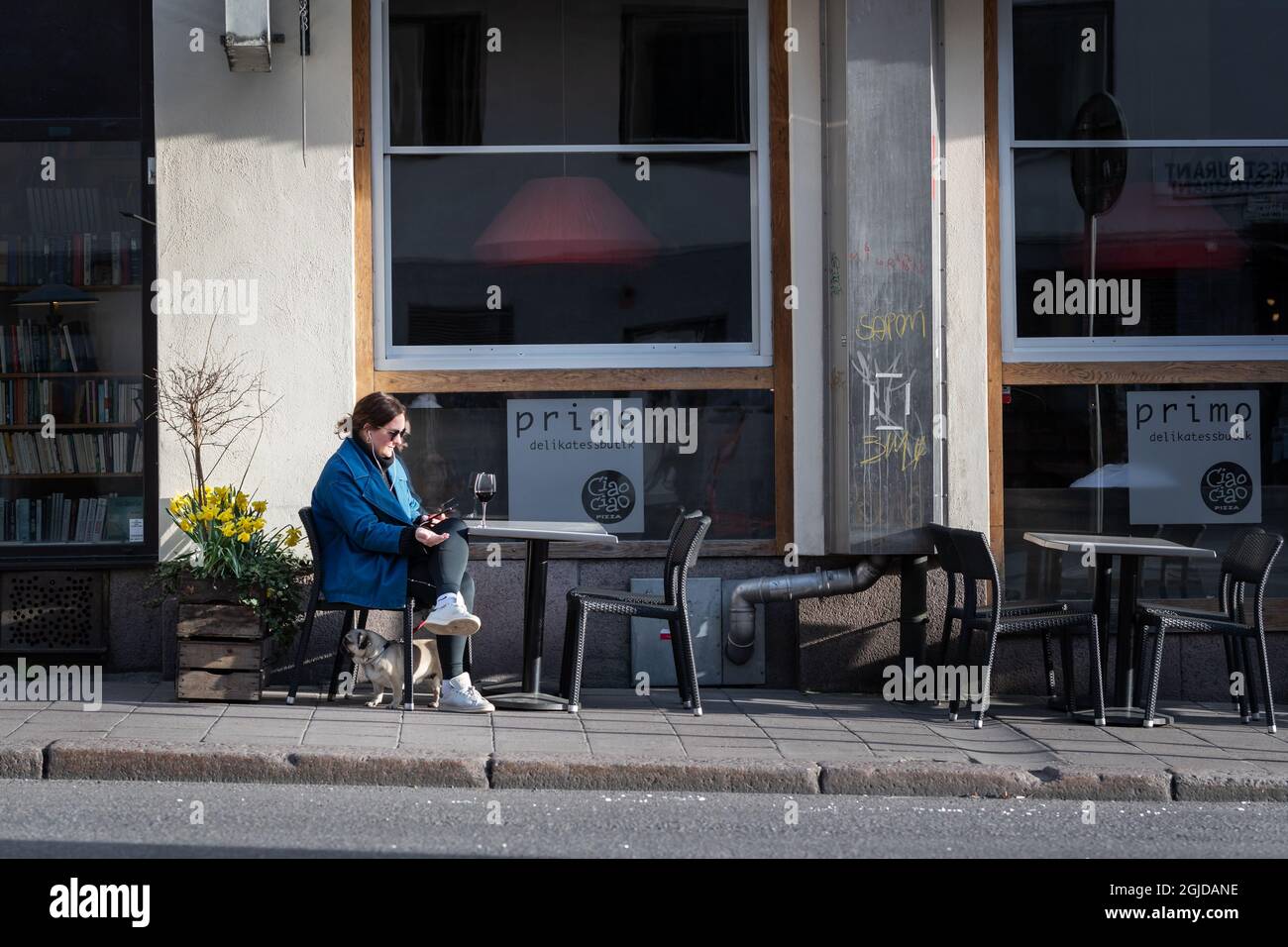 Une femme prenant un verre de vin à une table devant un restaurant à Sodermalm, Stockholm, Suède, 17 avril 2020, pendant la pandémie du coronavirus. Photo: Stina Stjernkvist / TT code 11610 Banque D'Images