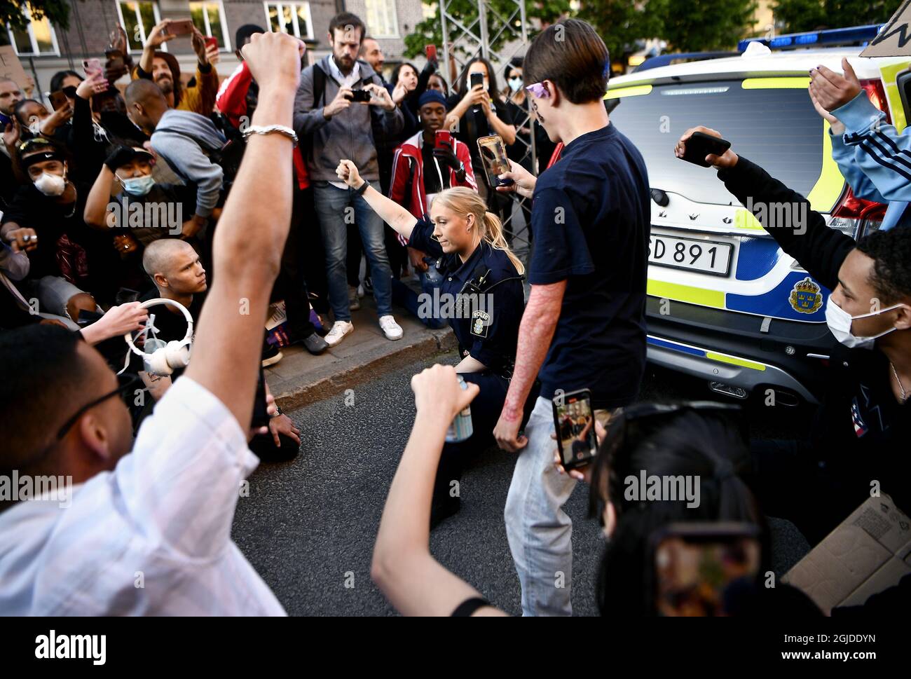 Un policier s'est arrêté sur ses genoux après avoir encerclé la voiture de police. Des milliers de manifestants à Stockholm pour montrer leur soutien à la vie noire sont contre le racisme. La manifestation a commencé sur la place de Sergel, puis s'est étalée sous la surveillance de la police, Stockholm, Suède, 2020-06-03 photo: Alex Ljungdahl / Expressen / TT / code 7179 Banque D'Images