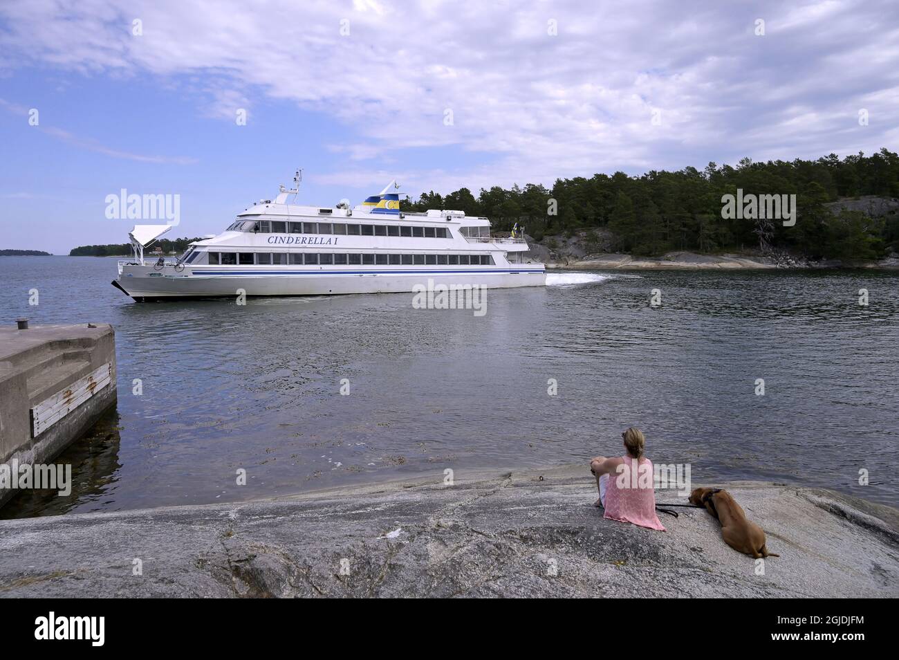 Une femme avec un chien et un bateau dans l'archipel de Stockholm. Photo Janerik Henriksson / TT code 10010 Banque D'Images