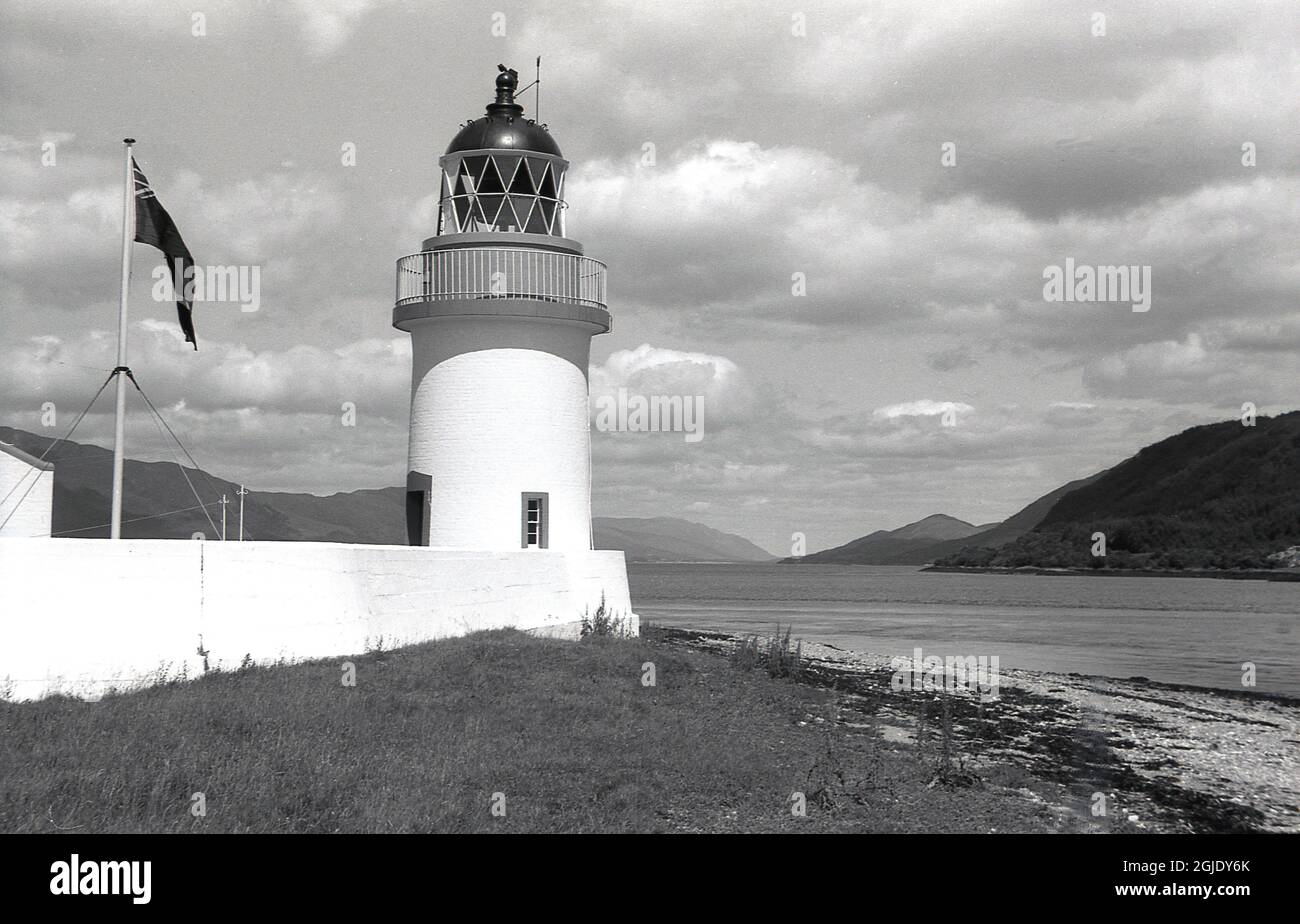 Années 1950, historique, le phare de Corran point sur la rive du Loch Linnhe, Ardgour, près de fort William dans les montagnes écossaises, Écosse, Royaume-Uni. Construit en 1857 par le père et l’oncle de Robert Louis Stevenson, il faisait partie d’une chaîne de phares marquant la route vers le canal calédonien. Banque D'Images